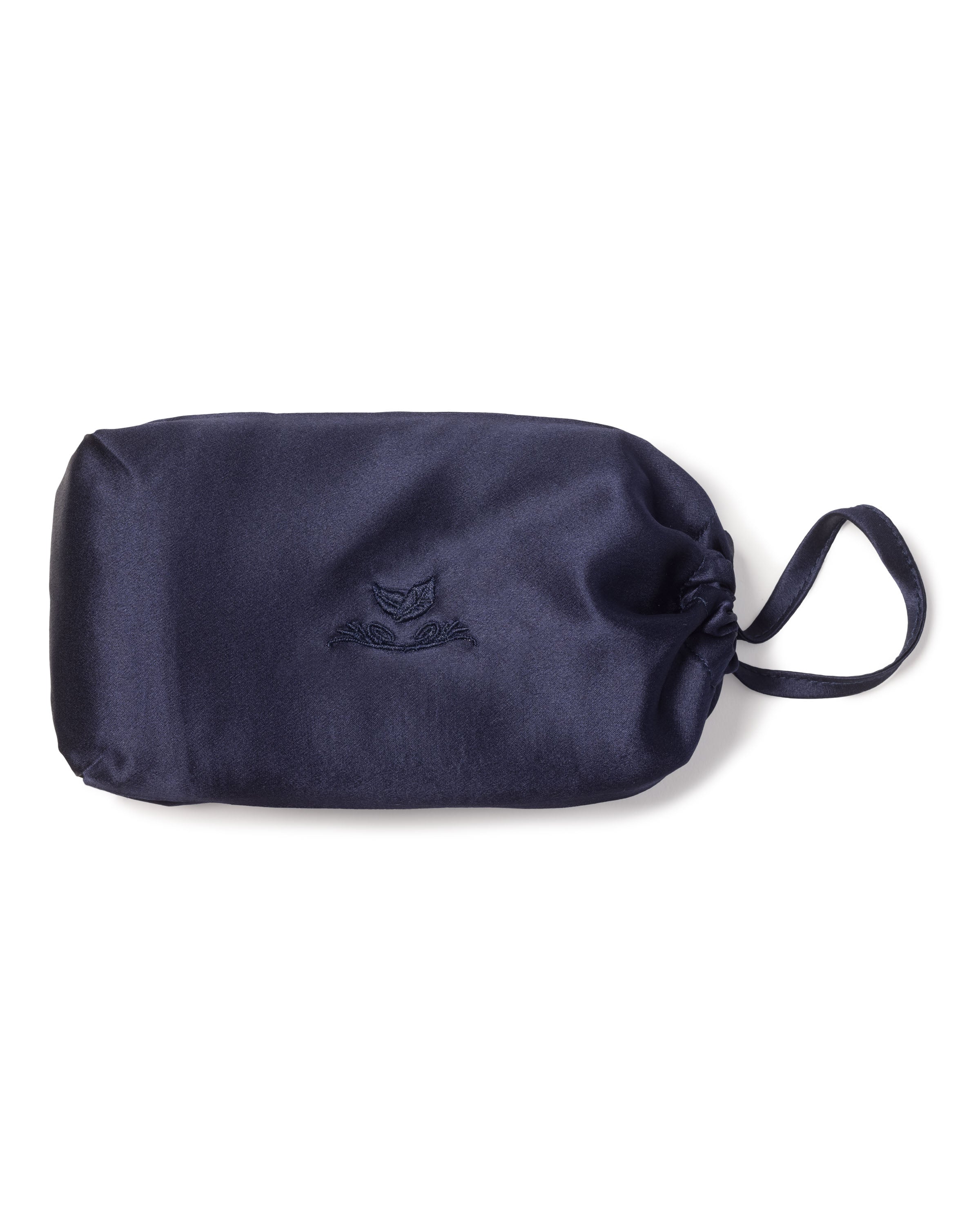 Petite Plumes Silk Pillow Cover in Navy features an embossed owl design on a navy blue satin pouch with a drawstring closure and side handle, evoking the luxury of silk pillowcases against a crisp white background, promising the sweetest dreams.