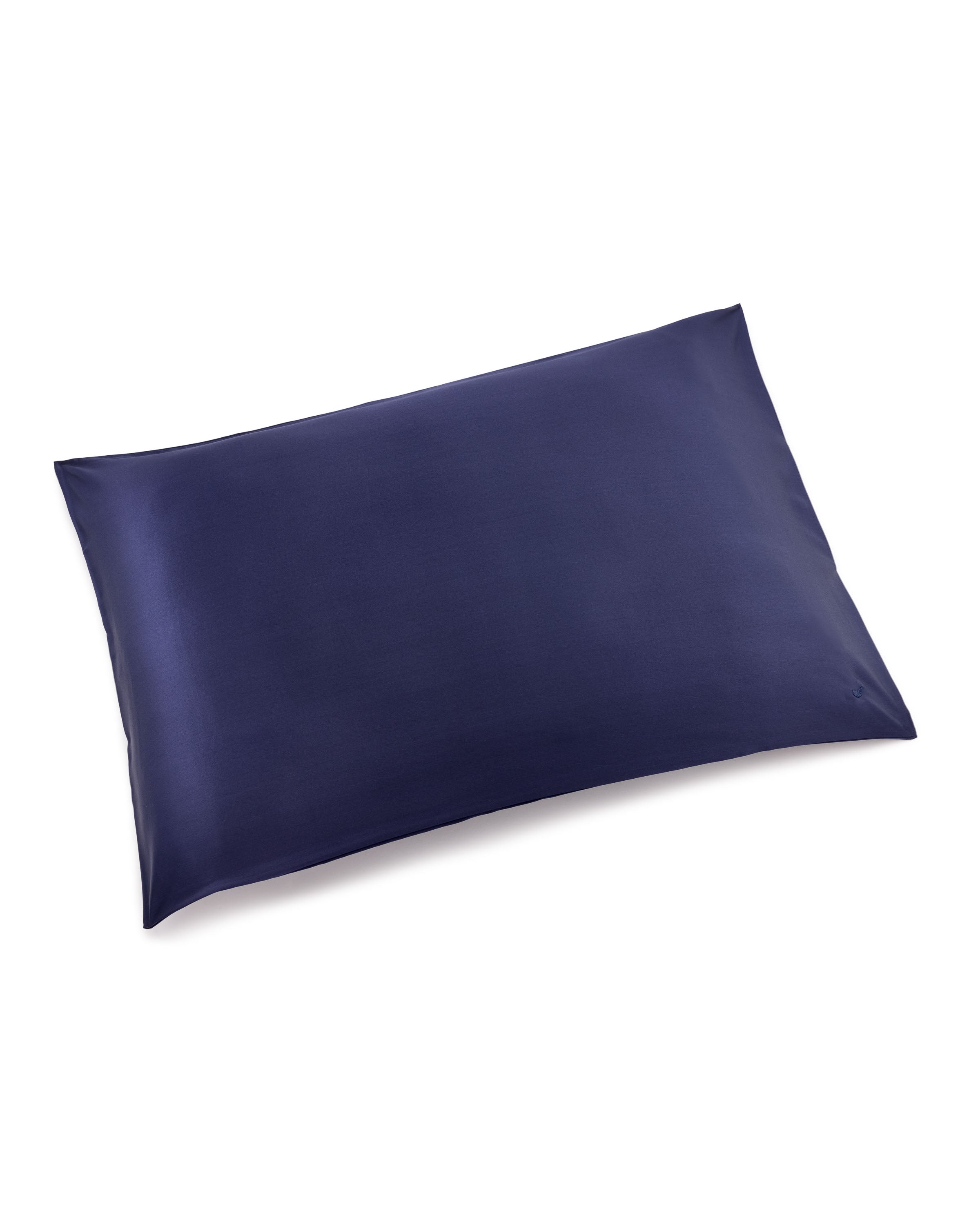 The Silk Pillow Cover in Navy by Petite Plume, made of 22mm pure silk, is rectangular with clean edges. Its smooth and glossy finish reflects light subtly against a white background, promising sweet dreams.