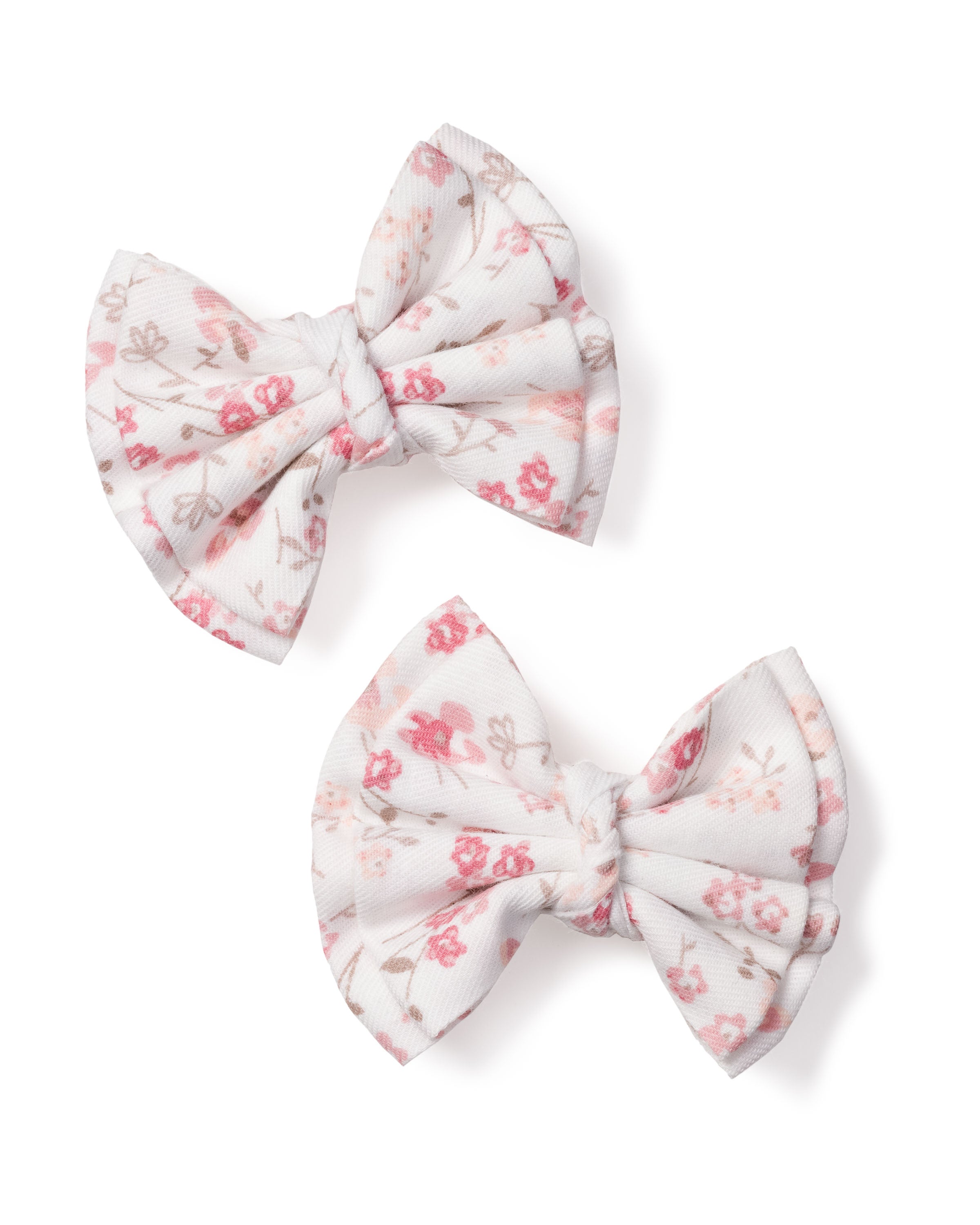 Two Dorset Floral Hair Bows from Petite Plume, featuring a white background with a pink floral pattern, are beautifully laid out on a white surface. These girls hair bows are perfect as stocking stuffers, with gathered pleats creating an elegant and delicate look.