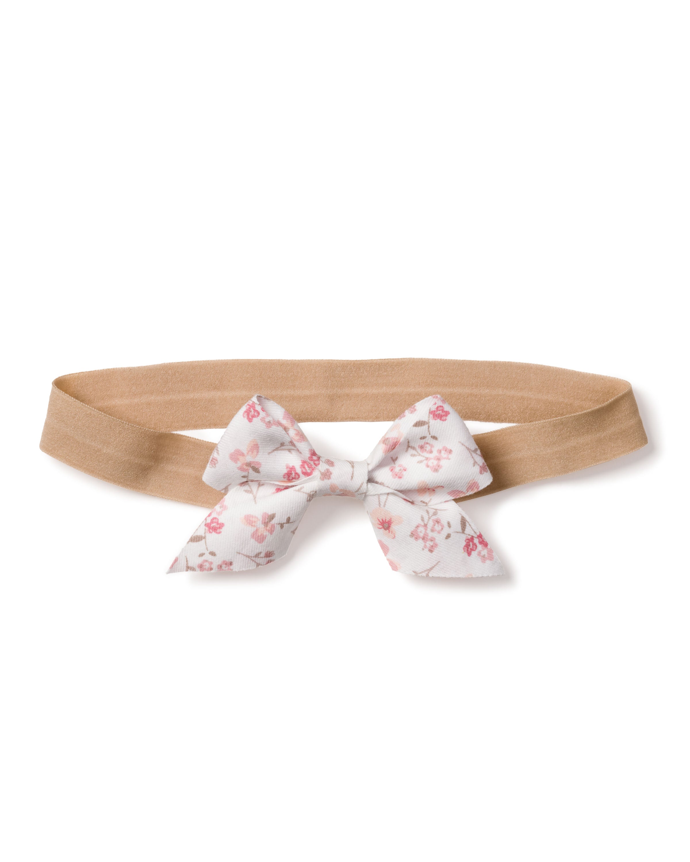 The Girls Dorset Floral Hair Bow by Petite Plume, a beige elastic headband with a white background and pink floral bow, is perfect for girls holiday gift collections as a charming stocking stuffer.