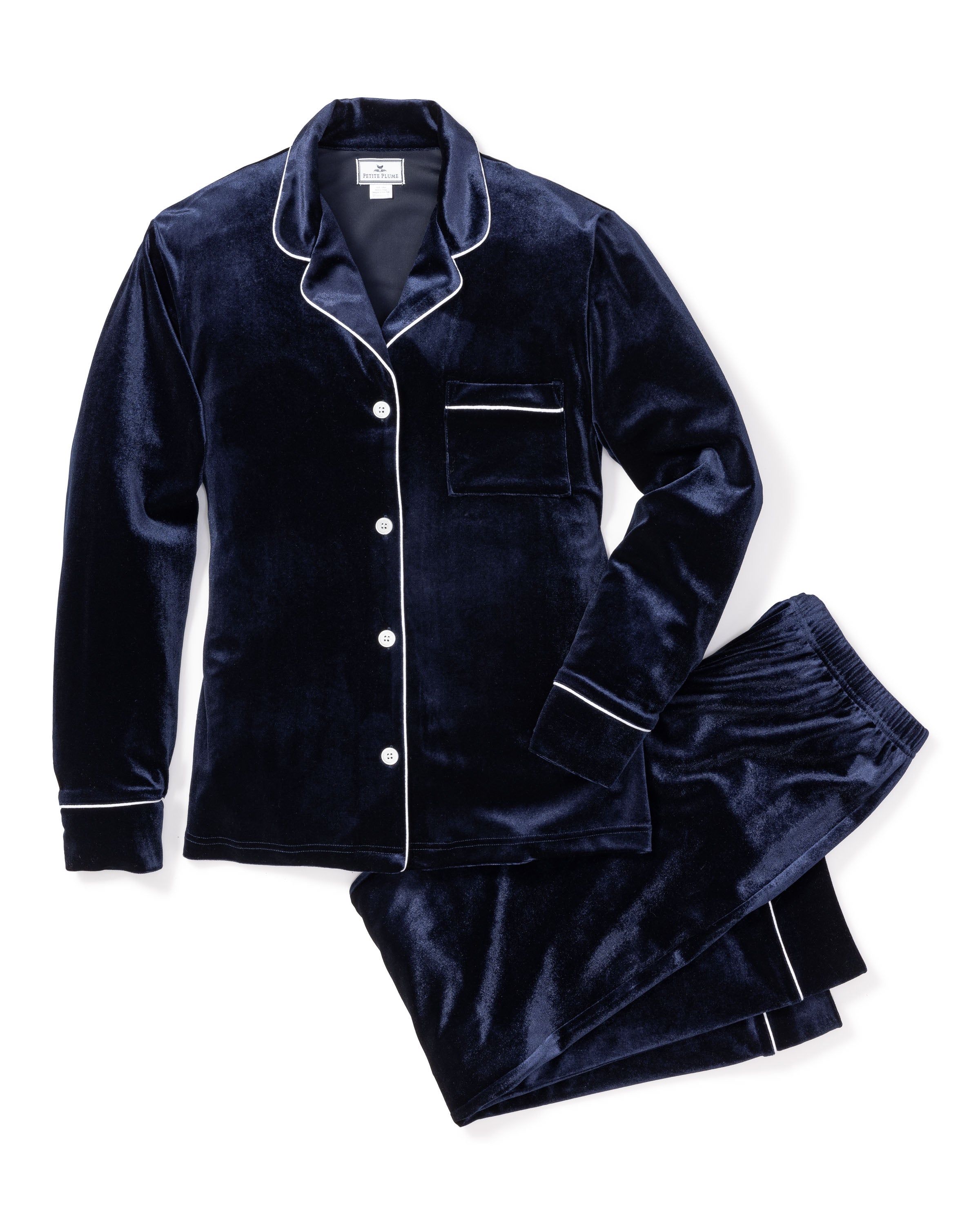 The Petite Plume Womens Velour Pajama Set in Navy, featuring classic white piping, includes a button-up long-sleeve top with a breast pocket and matching pants. This luxurious set promises ultimate comfort and evokes timeless Hollywood elegance from the Cabaret Collection.