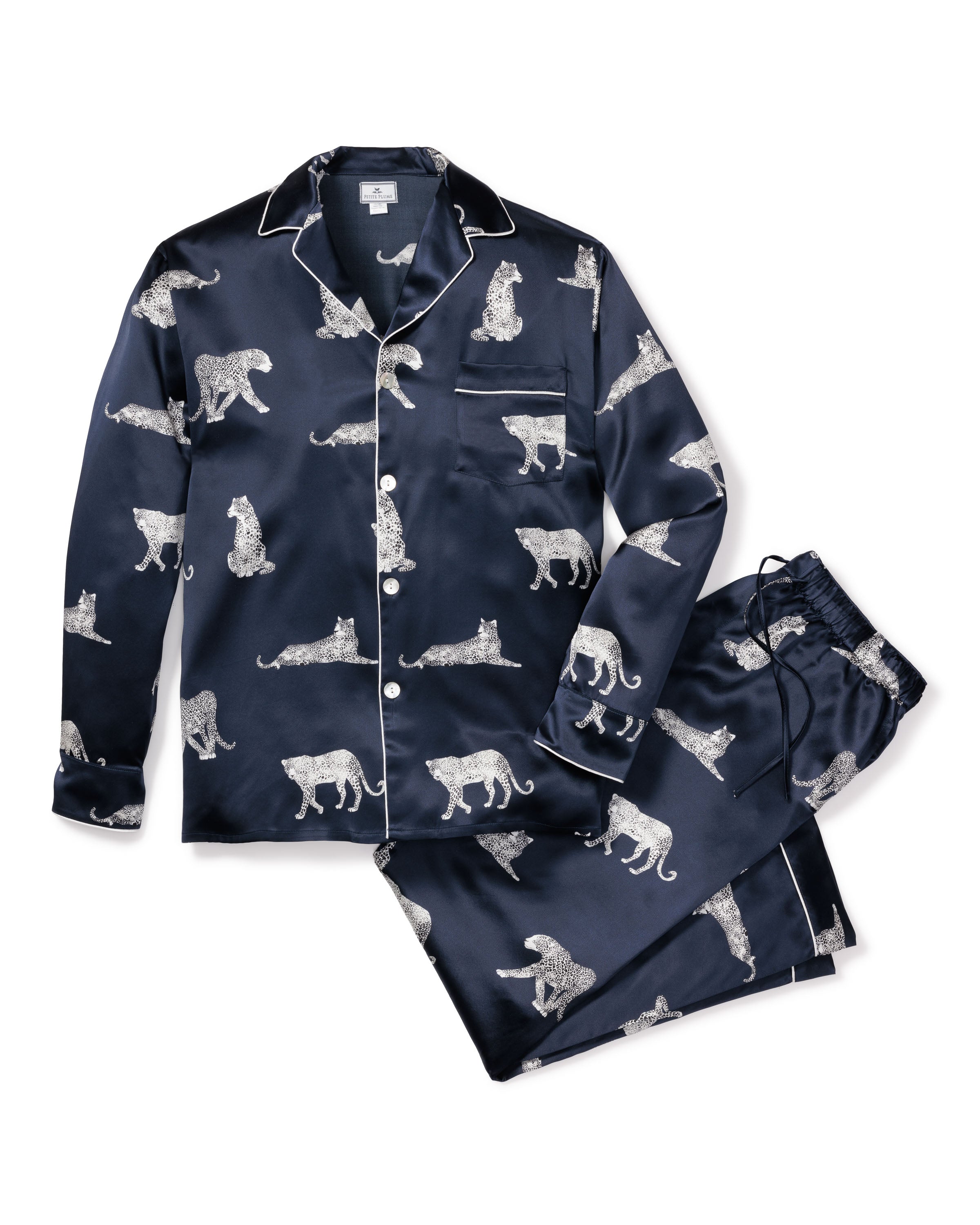 The Mens Silk Pajama Set in Panthère de Nuit by Petite Plume features a Hollywood-style navy blue satin with silver leopard illustrations, including a long-sleeve button-up top with chest pocket and matching drawstring waist pants, offering the luxurious feel of silk sleepwear.