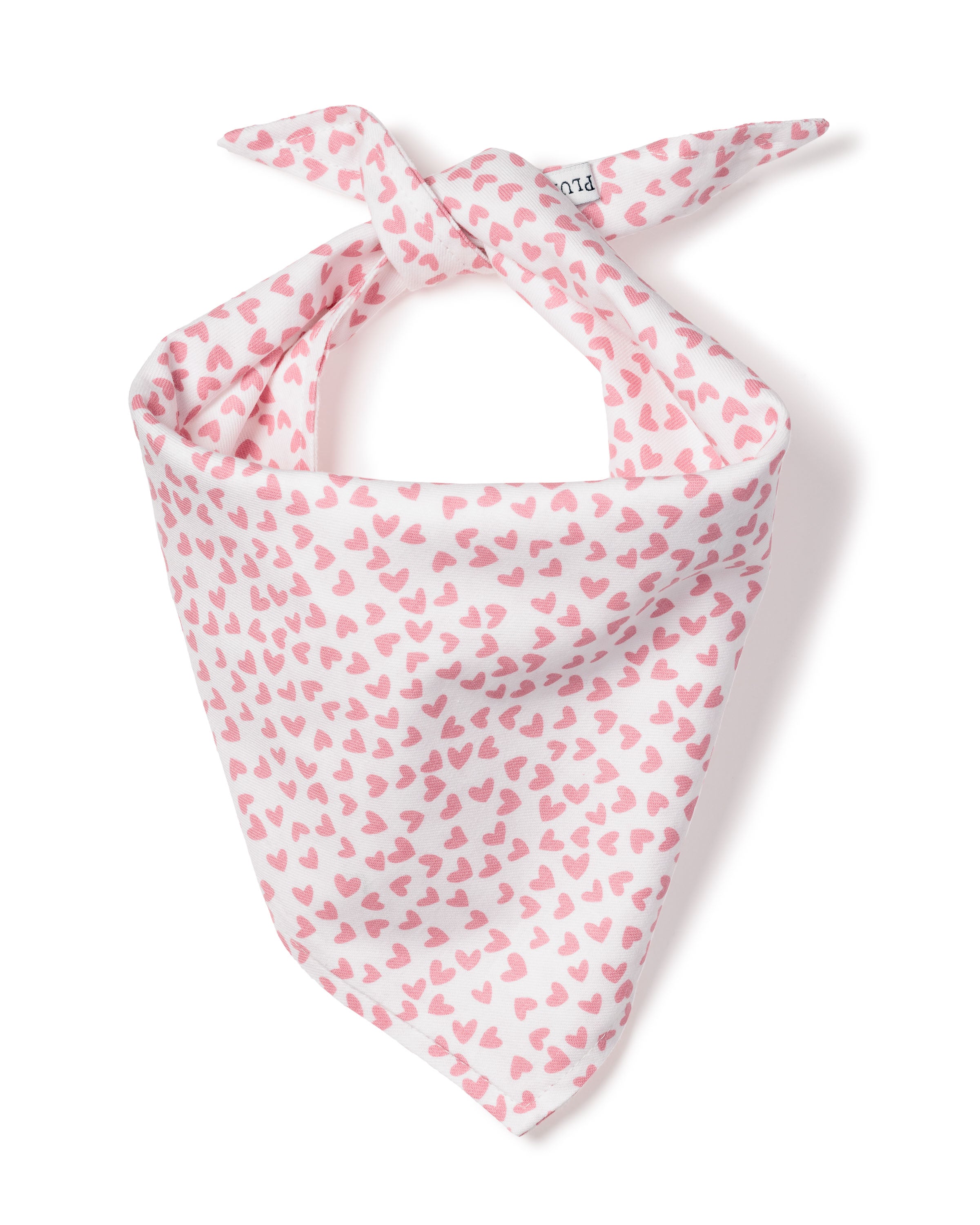 The Petite Plume Sweethearts Dog Bandana features a pattern of small pink hearts on white fabric. Its tied at the top and elegantly displayed on a plain white background, blending style and practicality like high-end dog accessories.