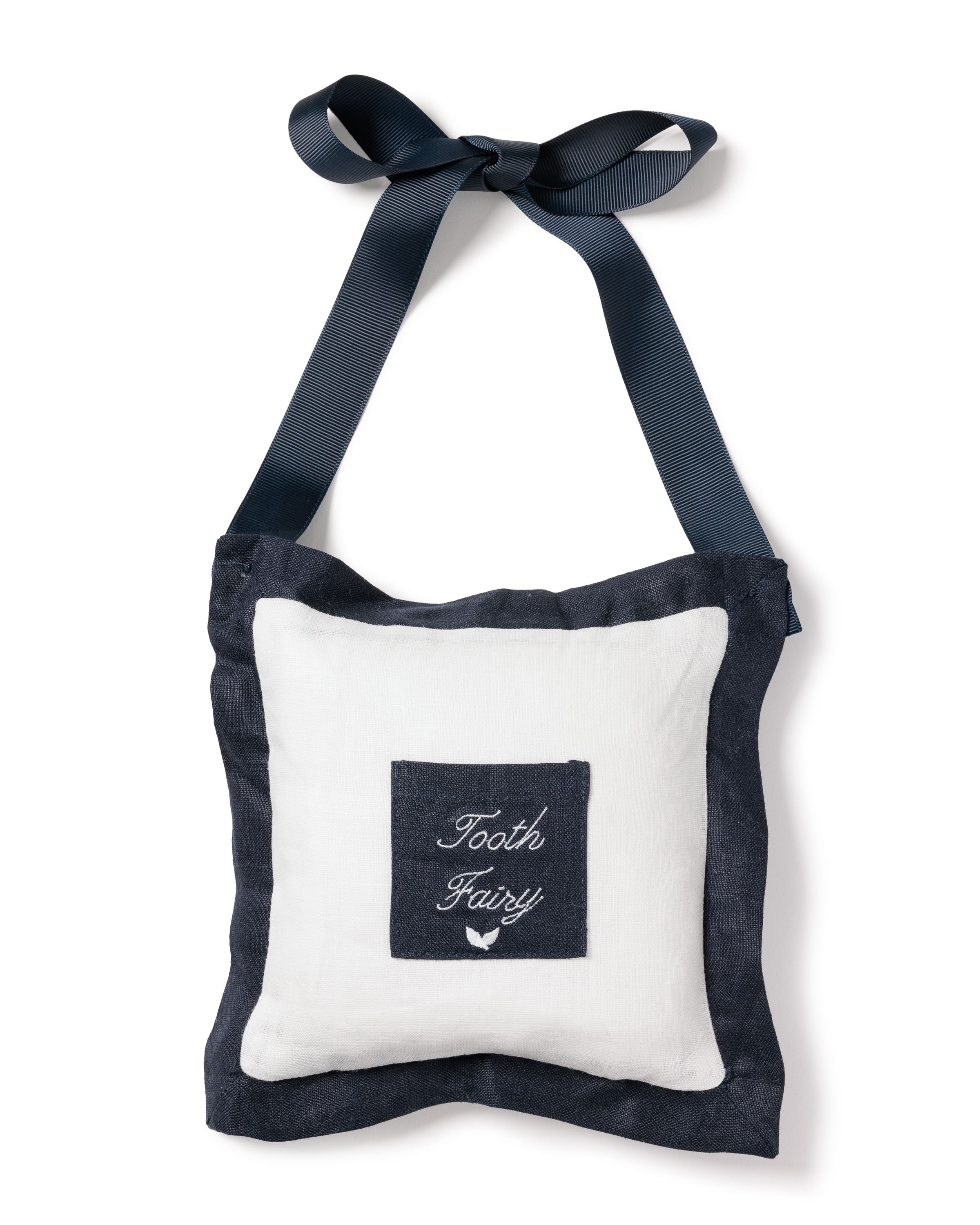 The Navy Tooth Fairy Pillow by Petite Plume features navy blue edges, a white center, and an embroidered Tooth Fairy patch pocket with a tiny tooth icon. It includes a detachable blue fabric handle for easy hanging.