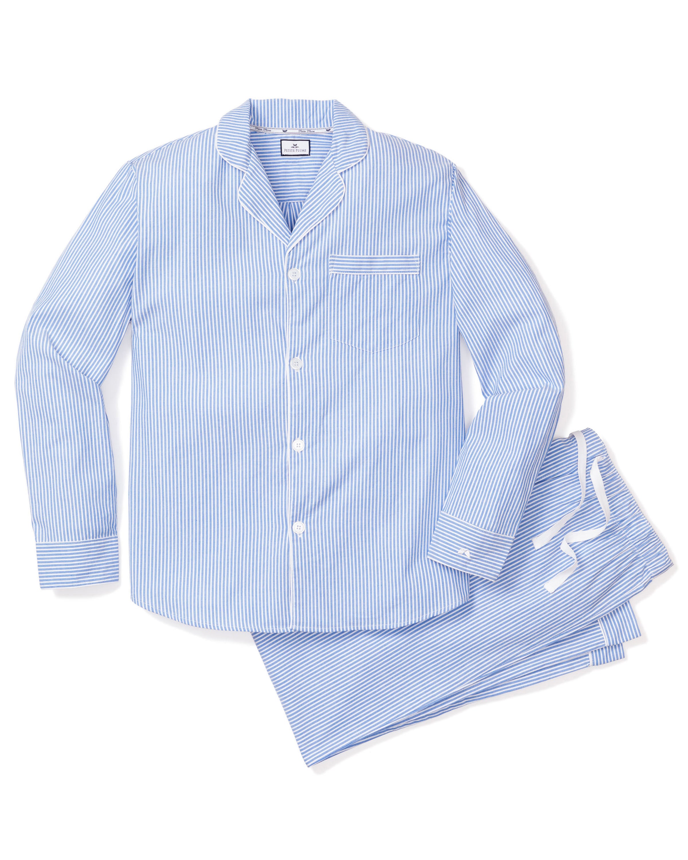 The Petite Plume Mens Twill Pajama Set in French Blue Seersucker features a long-sleeve button-up top with a chest pocket and matching pants, all neatly folded. This luxury sleepwear offers a classic, crisp look thats timeless and comfortable.