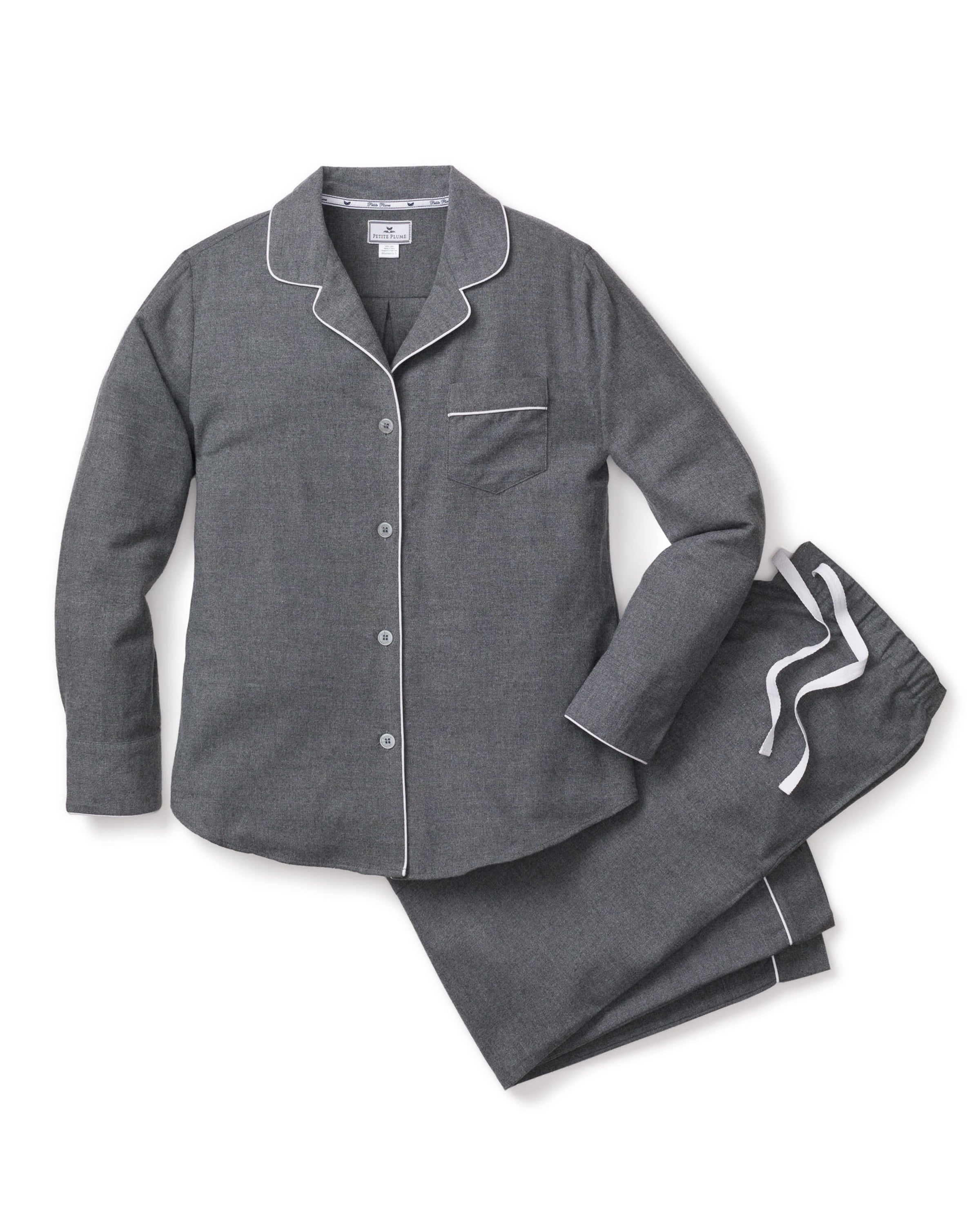 The Womens Flannel Pajama Set in Grey by Petite Plume features a neatly folded set with white piping, including a long-sleeved button-up shirt with a chest pocket and matching pants with white drawstrings.