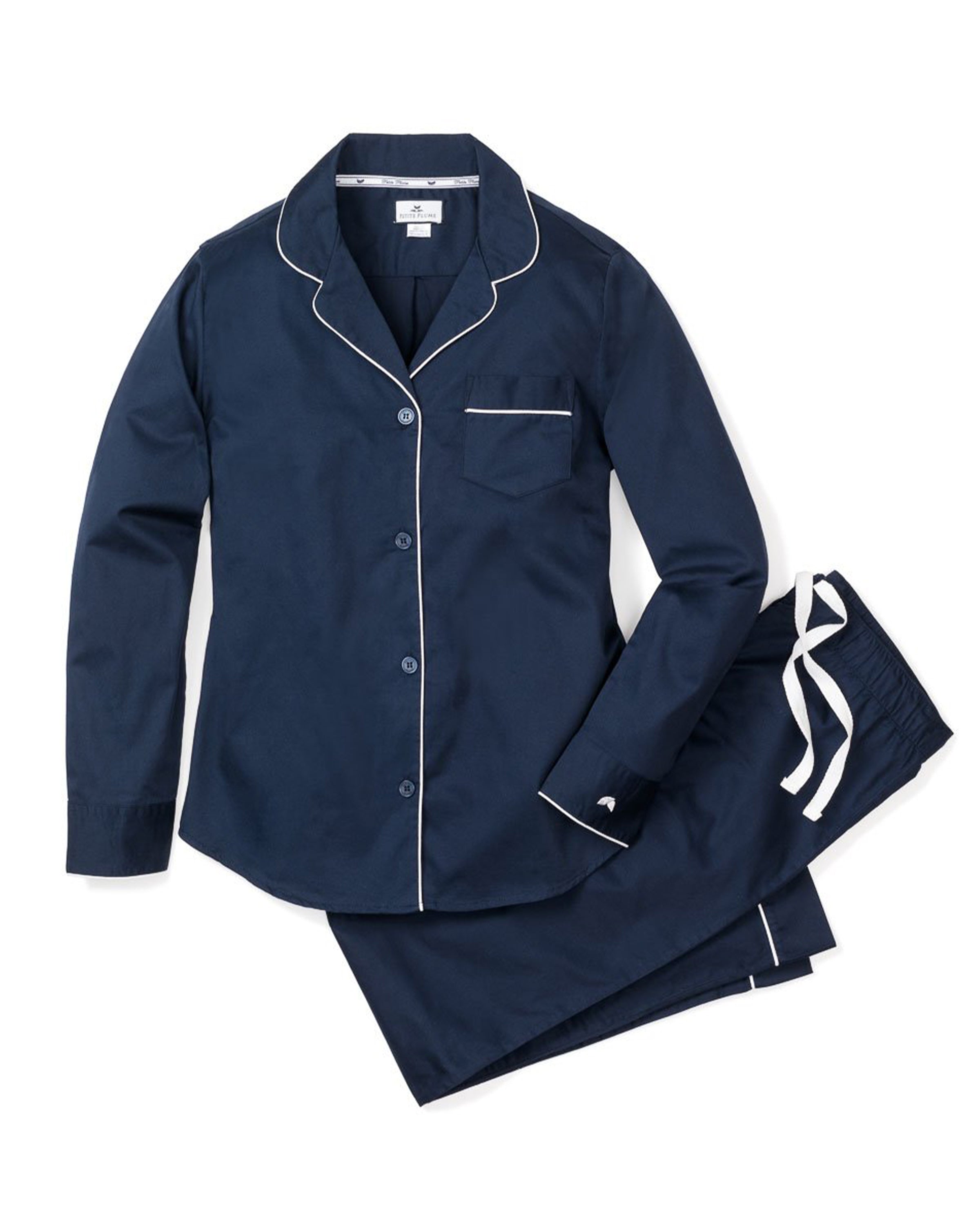 The Womens Twill Pajama Set in Navy by Petite Plume features a dark blue long-sleeve button-up top with white piping, a chest pocket, and drawstring waist pants. Made from 100% cotton twill, this set is smooth, comfortable, and moisture-wicking.