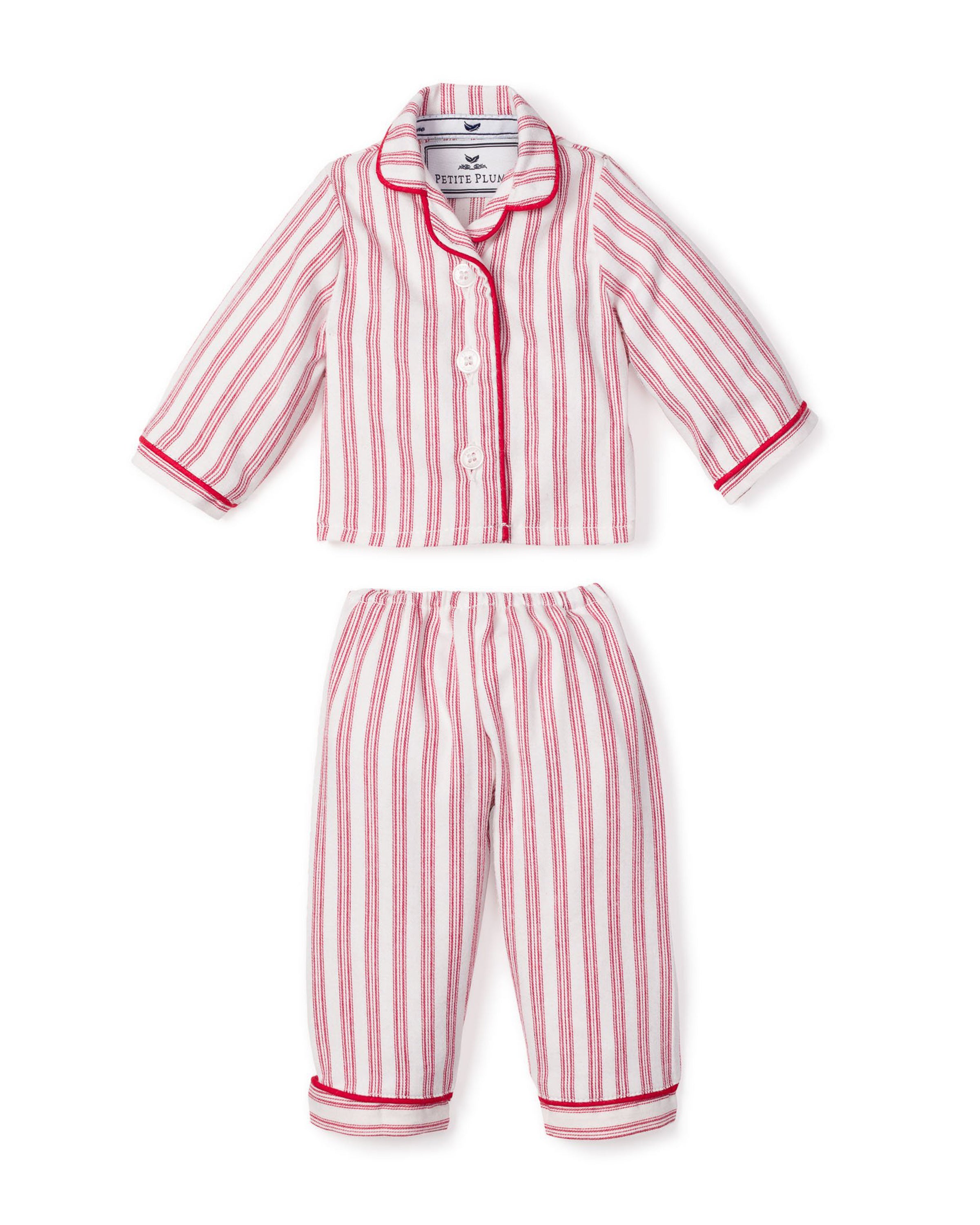 The Petite Plume Doll Pajamas in Antique Red Ticking include a red and white striped childs pajama set with a collared button-up top and relaxed pants with cuffed hems. Ideal for bedtime fun, they allow your child to match their favorite 18 doll in cozy style.