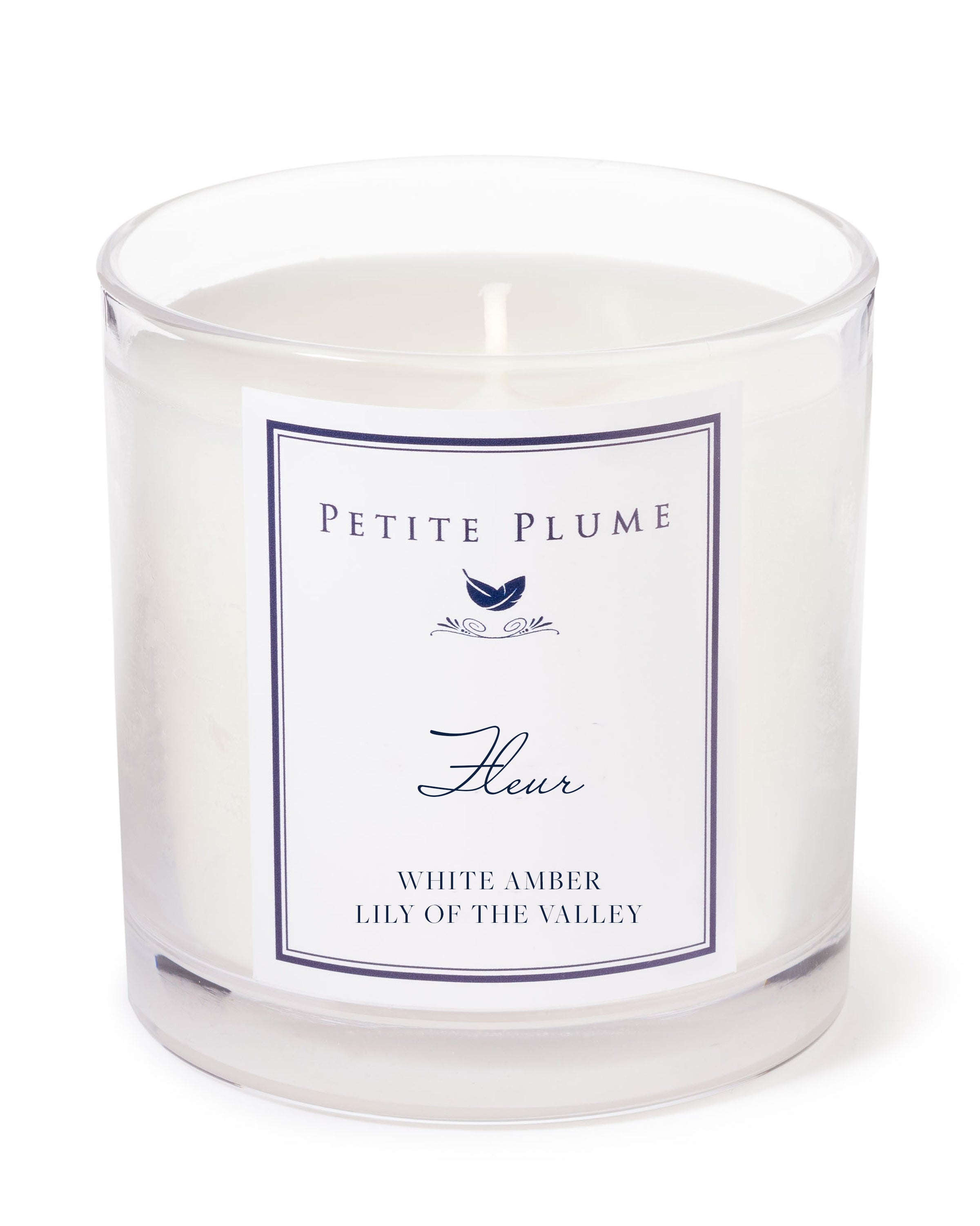 Experience the enchantment of the Petite Plume Fleur Candle, a white candle elegantly housed in a clear glass holder. With Petite Plume and Fleur labels, it infuses your space with the exquisite fragrance of White Amber & Lily of the Valley.
