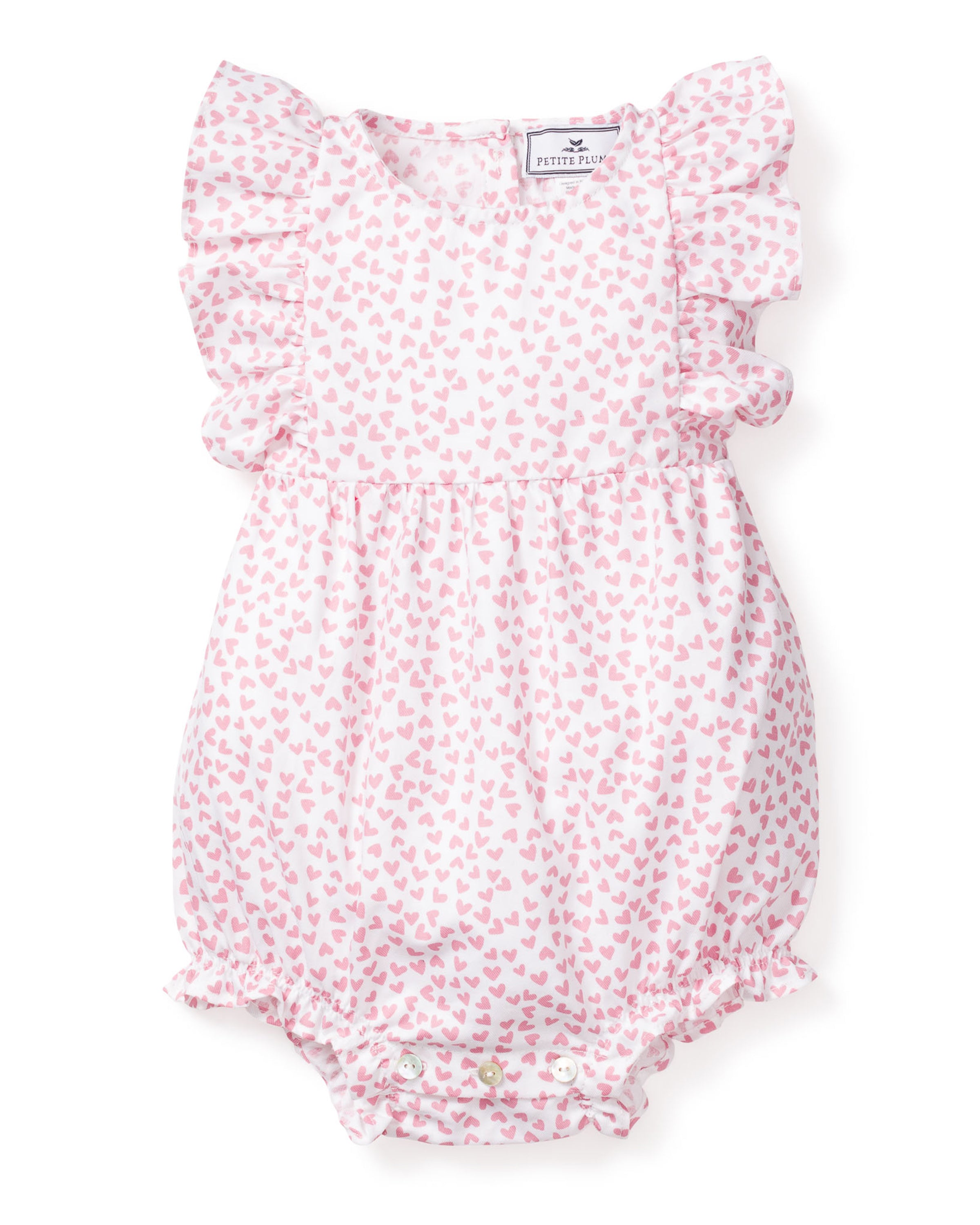 Petite Plumes Babys Twill Ruffled Romper in Sweethearts is a Victorian-inspired pink floral romper on white, featuring ruffled sleeves, trim with tiny pink hearts, and convenient bottom snaps for easy changing.