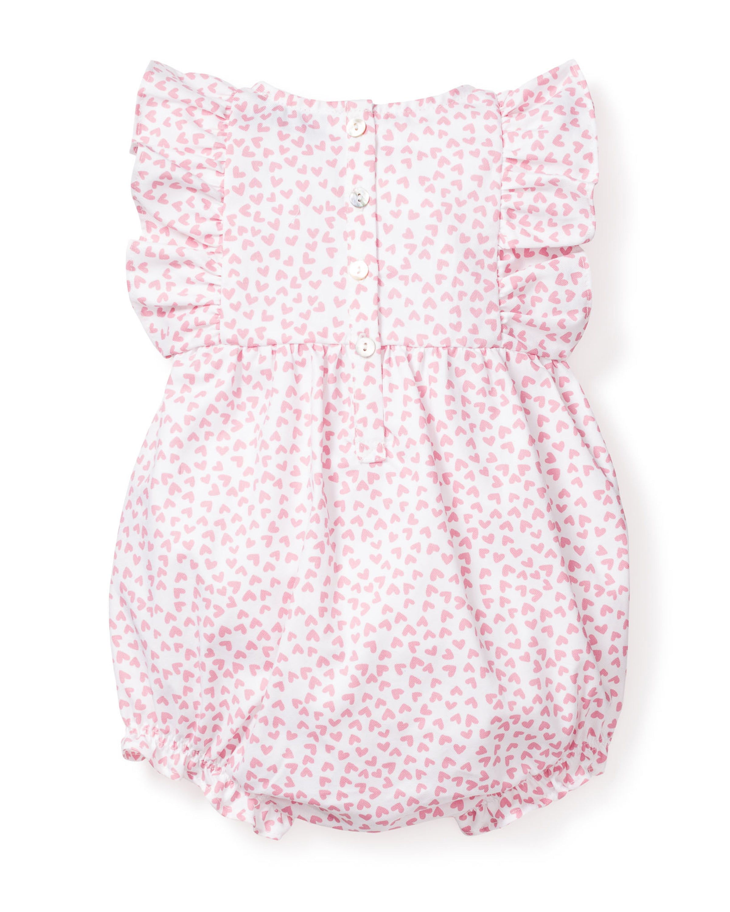 The Babys Twill Ruffled Romper in Sweethearts by Petite Plume is a Victorian-inspired infant romper with pink hearts, ruffled sleeves, and a button-up back. It has elastic leg openings for comfort and is crafted as flame retardant sleepwear, blending style and safety beautifully.