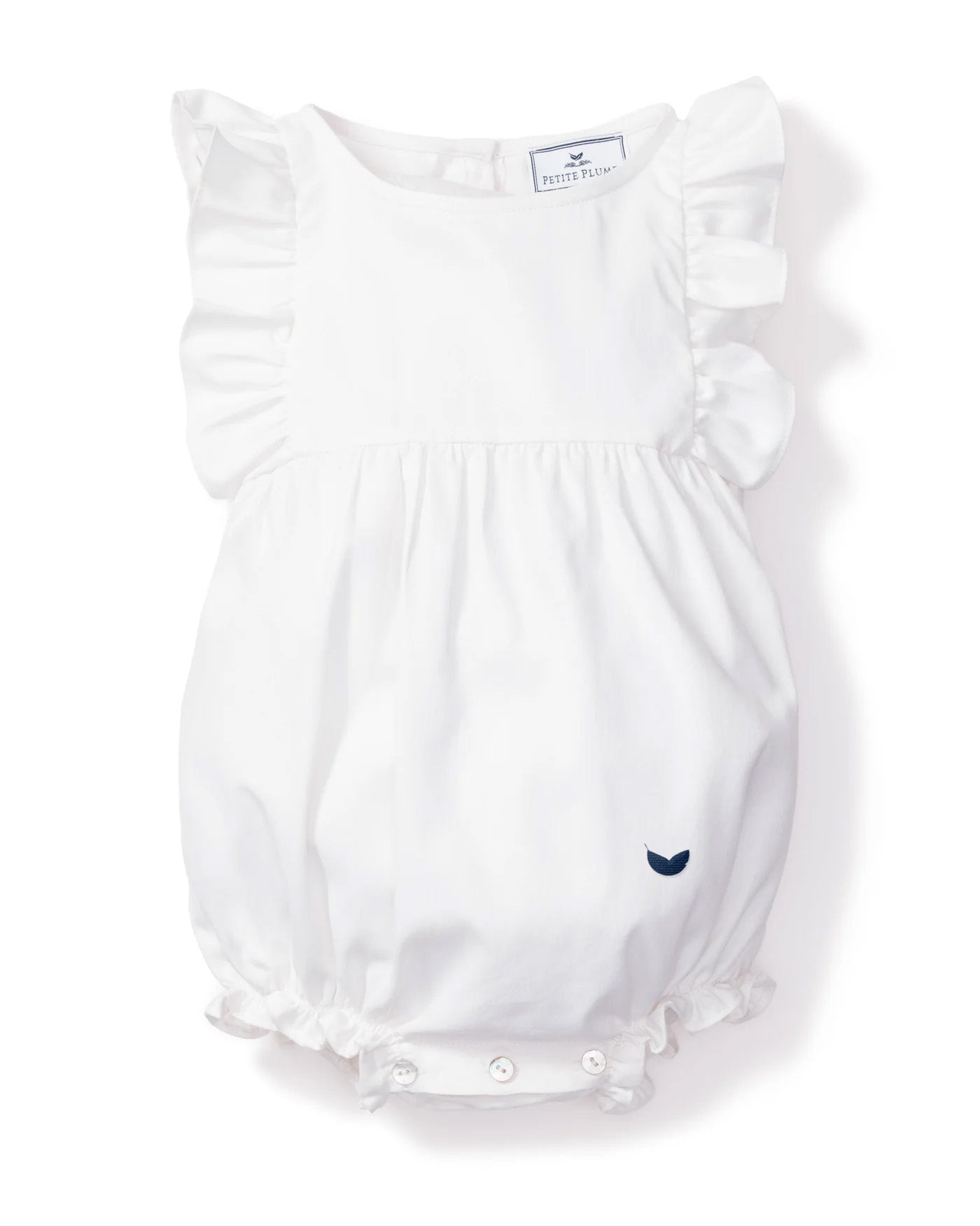 The Babys Twill Ruffled Romper in White by Petite Plume is made from soft, yarn-dyed cotton with ruffled sleeves and leg openings. It has a small navy blue bird design near the bottom and features buttons on the back for easy fastening, perfect for sleepwear.
