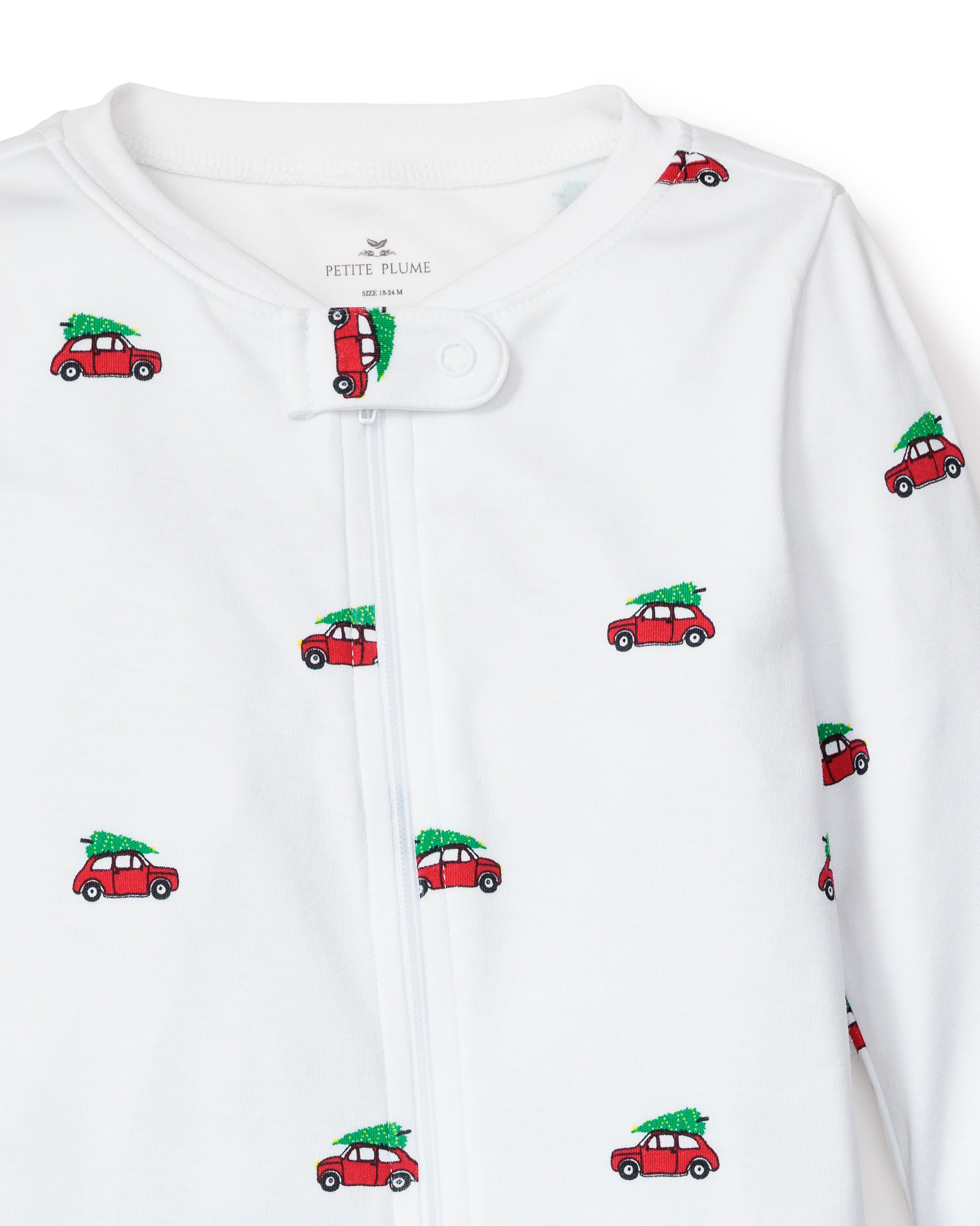 Petite Plumes Babys Pima Romper in Holiday Journey features a white infant onesie with soft Pima cotton and red car designs, each carrying a green Christmas tree. Snap button closure at the neckline ensures easy dressing, making it perfect for childrens sleepwear.