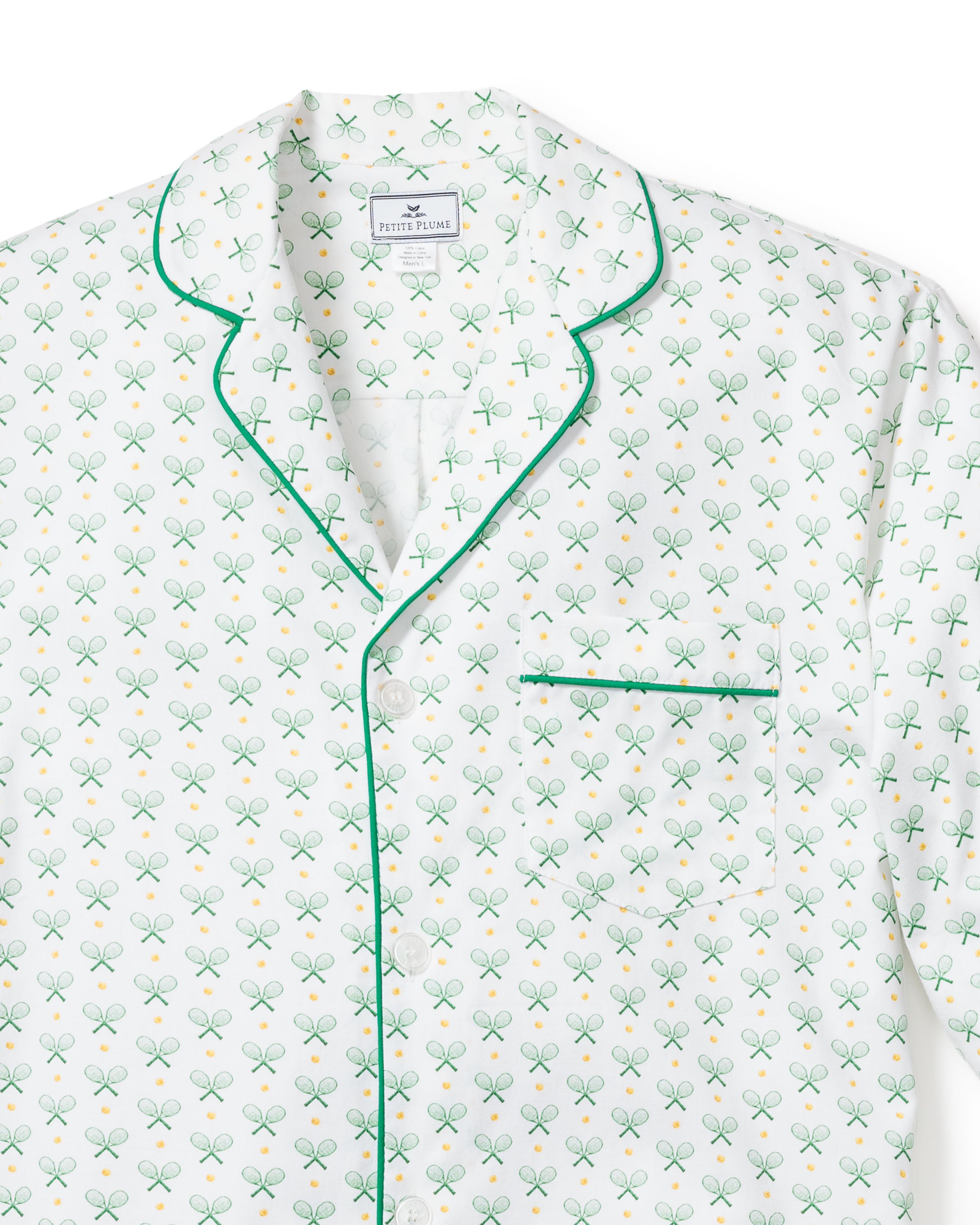 The Mens Twill Pajama Short Set in Match Point by Petite Plume includes a white long-sleeve top with a tennis racket and yellow ball pattern. Made from 100% cotton, it features green piping on the collar, buttoned front, and pocket edge for a refined touch.