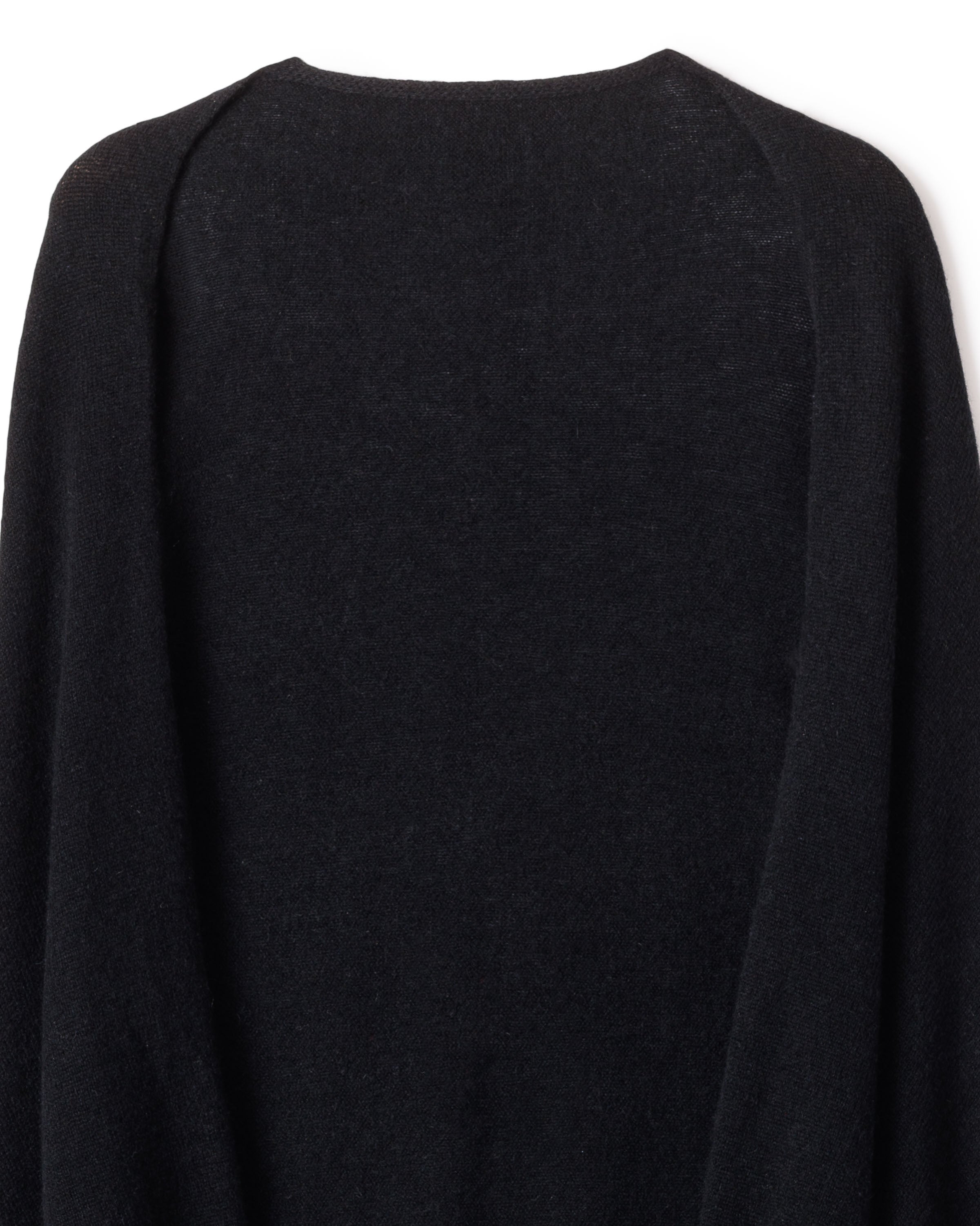 A close-up showcases the Womens Cashmere Wrap in Black by Petite Plume, draped in gentle folds. The Grade A cashmere fabric, with its subtle sheen, is photographed against a plain background to accentuate its rich color and smooth texture.
