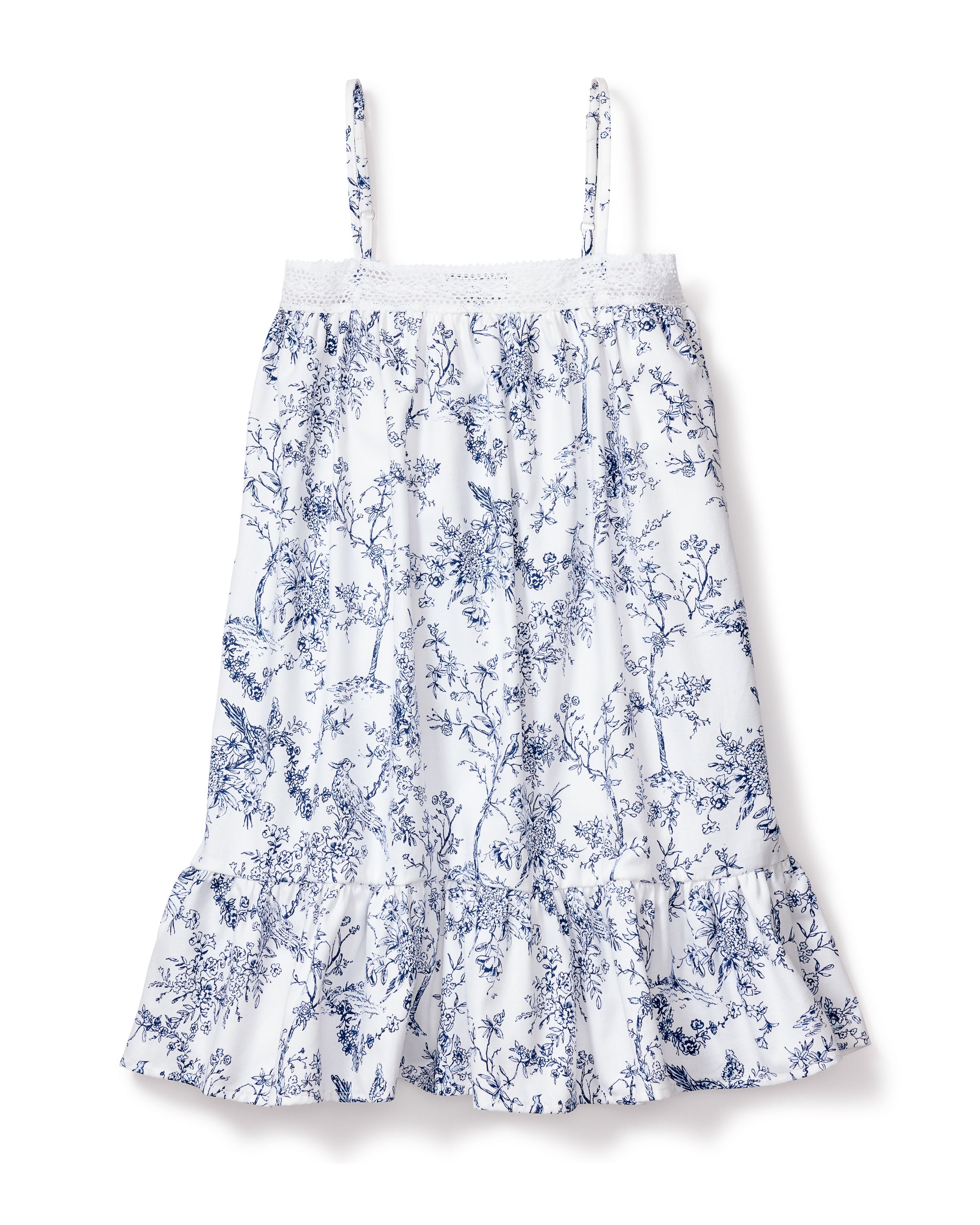 The Girls Twill Lily Nightgown in Timeless Toile by Petite Plume is a white sundress with blue floral patterns, featuring thin straps and a ruffled hem. Hand-drawn illustrations add botanical elegance, making it ideal for casual outings or luxurious sleepwear.