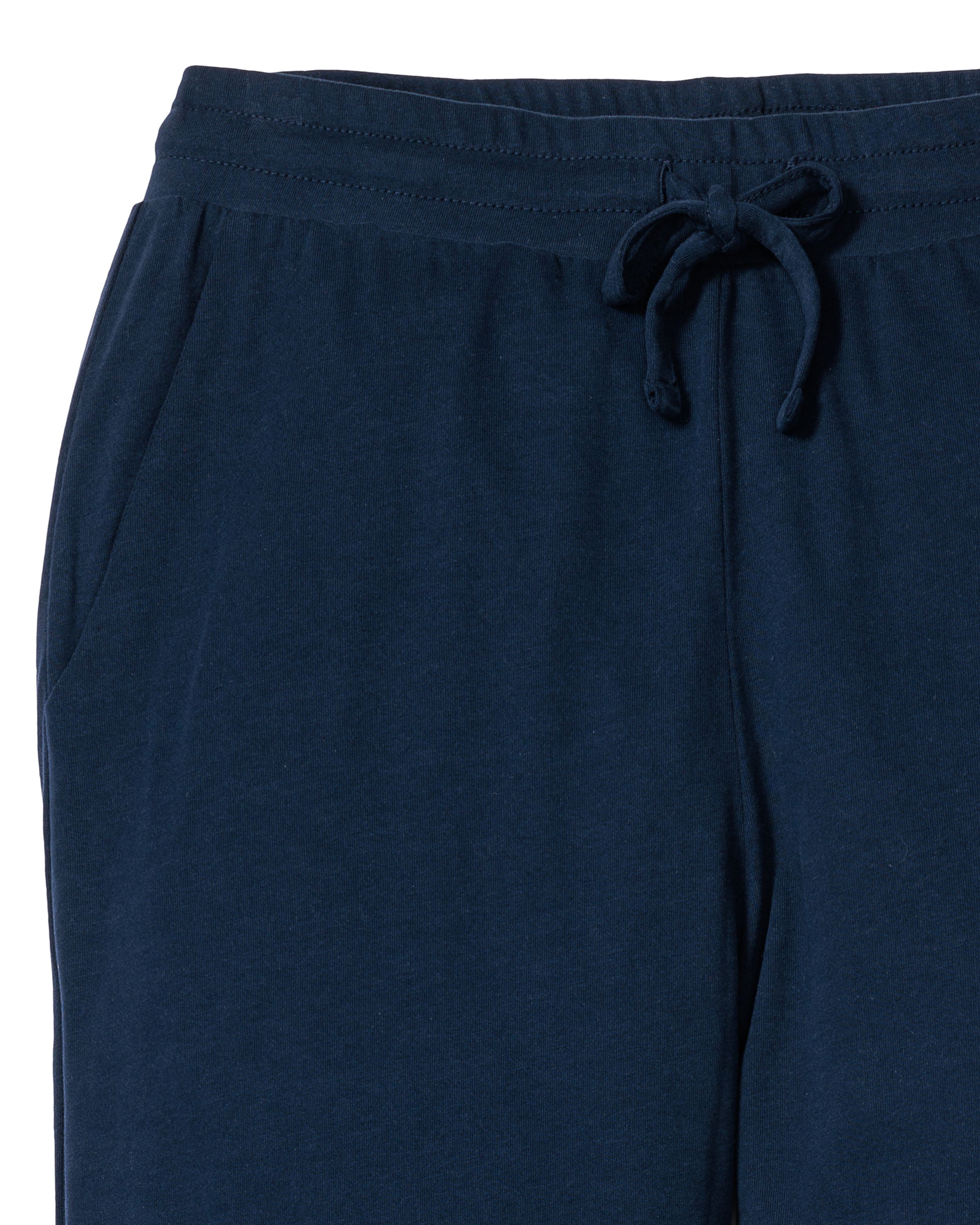 The Womens Pima Lounge Pants in Navy by Petite Plume are crafted from soft jersey knit fabric with an elastic waistband and drawstring. Made from Peruvian Pima cotton for comfort, they feature side pockets and are ideal for lounging or as luxurious pajamas.