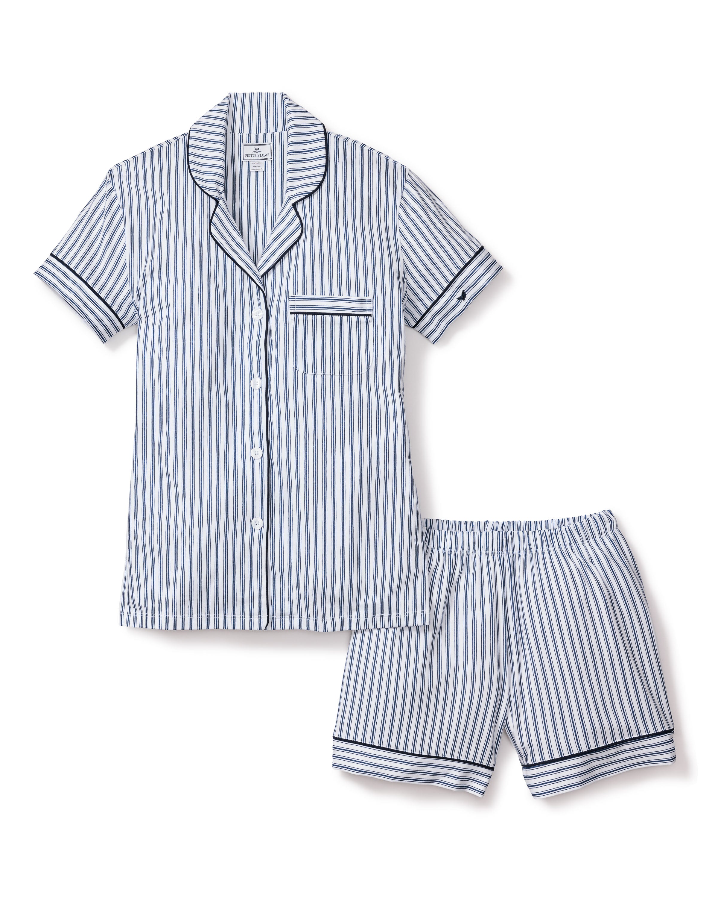 The Womens Pima Pajama Short Set by Petite Plume features a short-sleeved button-up shirt with a pocket and matching shorts, made from soft cotton twill. It boasts a light blue and white vertical stripe pattern akin to the classic French ticking design, enhanced with dark blue edge accents.