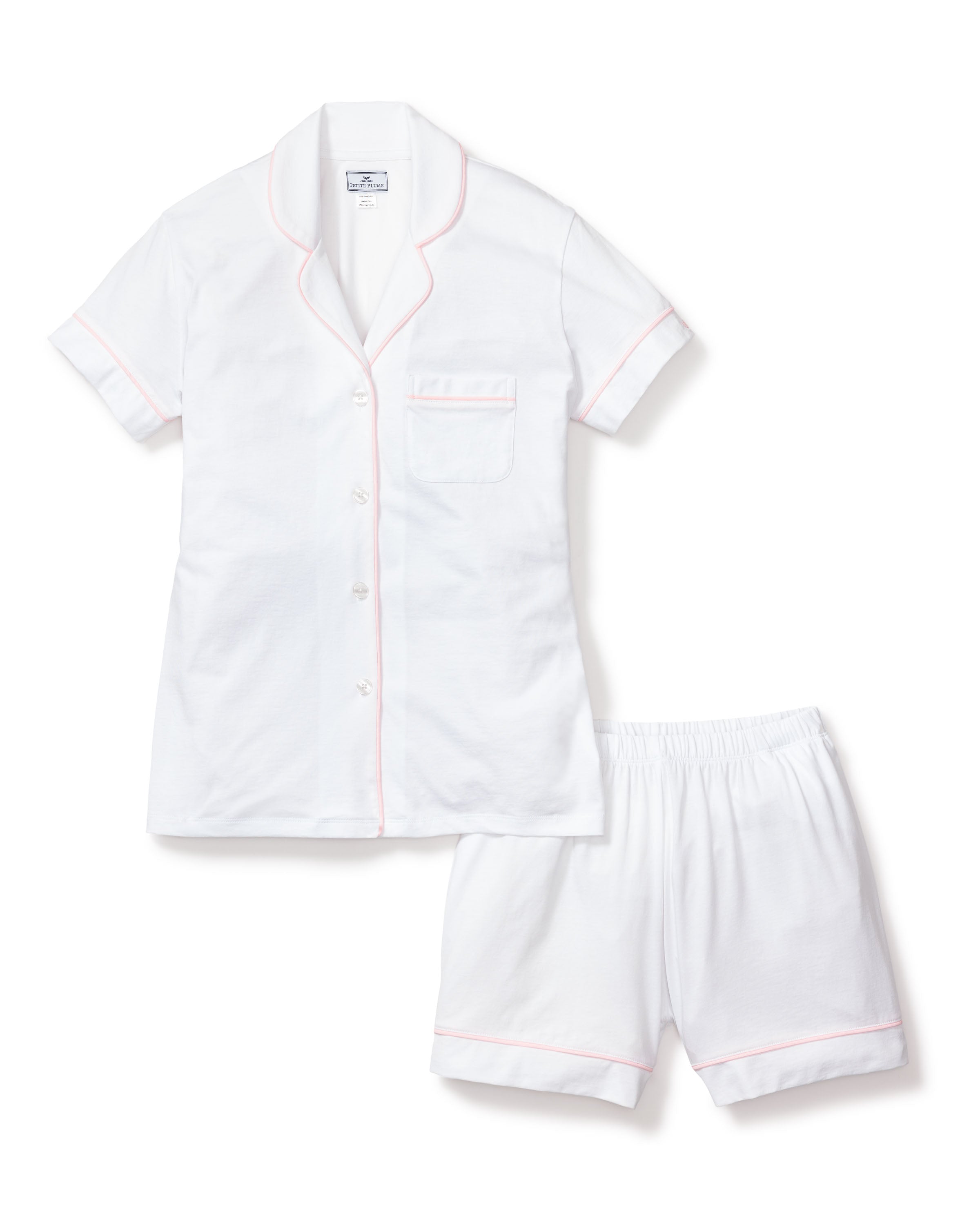 Immerse in luxury with Petite Plumes Womens Pima Pajama Short Set in White with Pink Piping, crafted from soft Peruvian Pima cotton. It includes a short-sleeve button-up shirt with chest pocket and matching shorts featuring an elastic waistband, ensuring comfort and style.