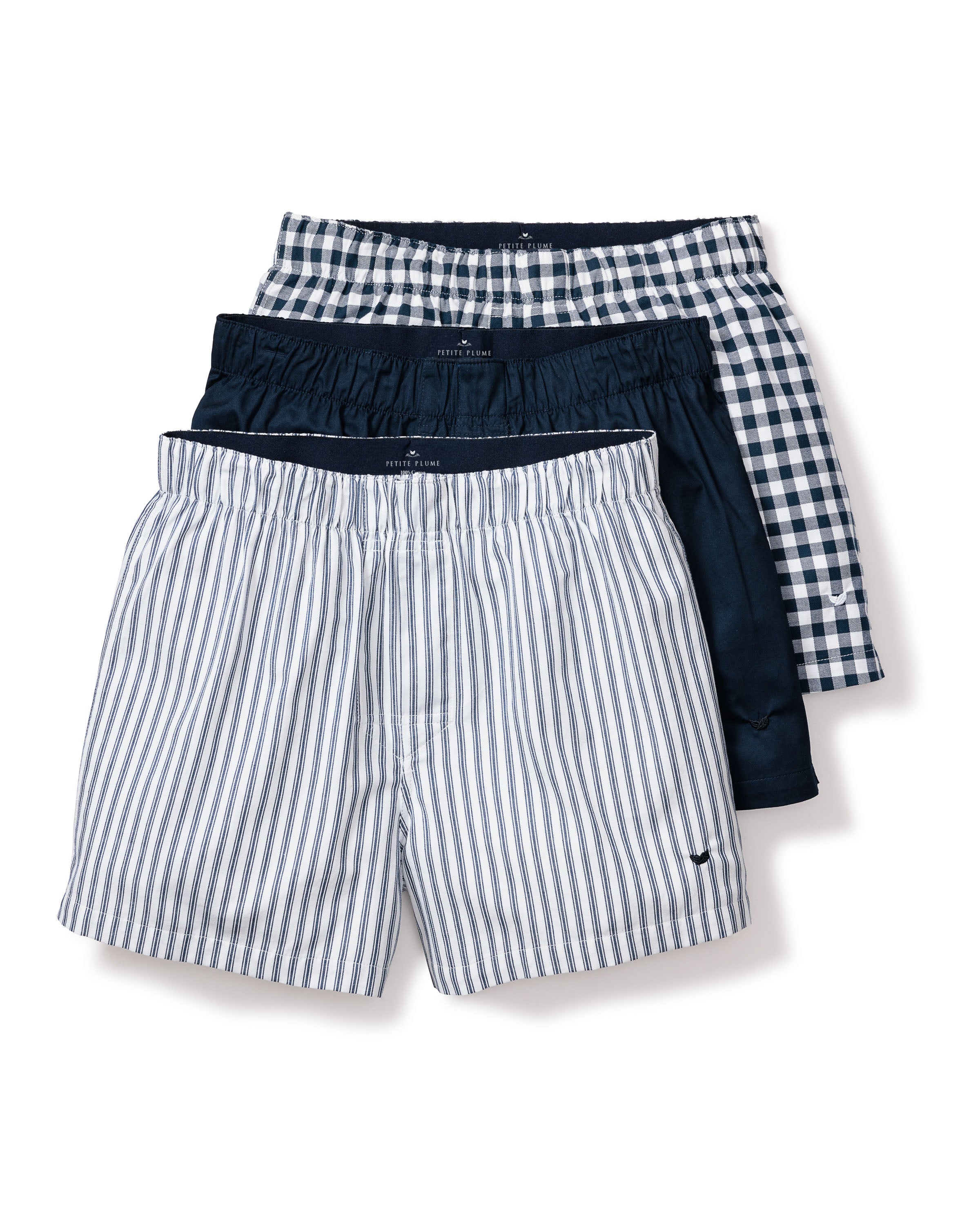 The Mens Twill 3 Pack Boxers in Navy by Petite Plume include three pairs: one with blue and white stripes in woven cotton twill, a solid dark blue pair, and a classic fit with blue and white checks. Each features an elastic waistband.