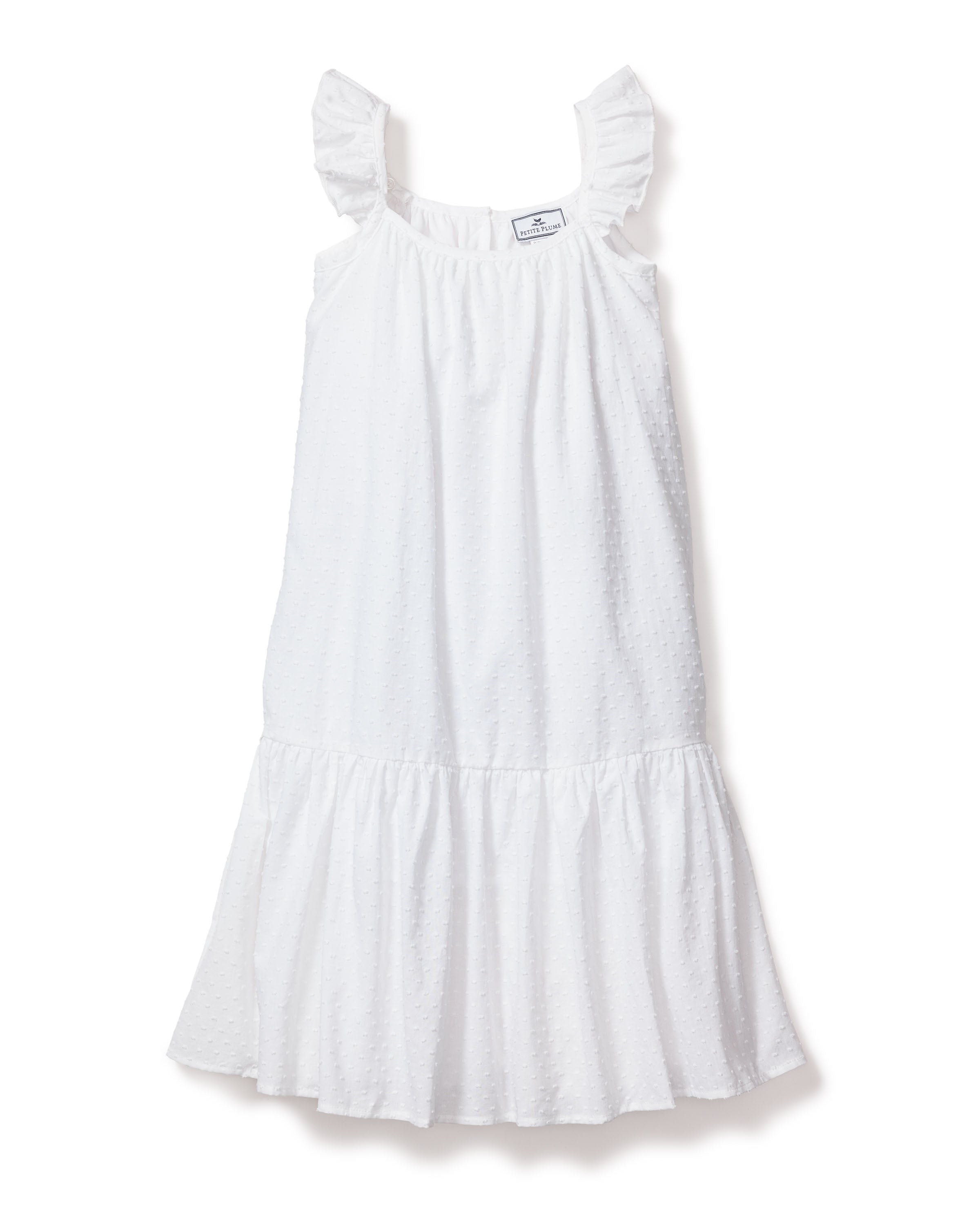 The Girls Swiss Dots Celeste Day Dress by Petite Plume is a sleeveless white sundress made from Swiss Dot Cotton. It features ruffled shoulder straps, a gathered waist, subtle dotted texture, and a flowing tiered skirt, making it ideal for warm days.