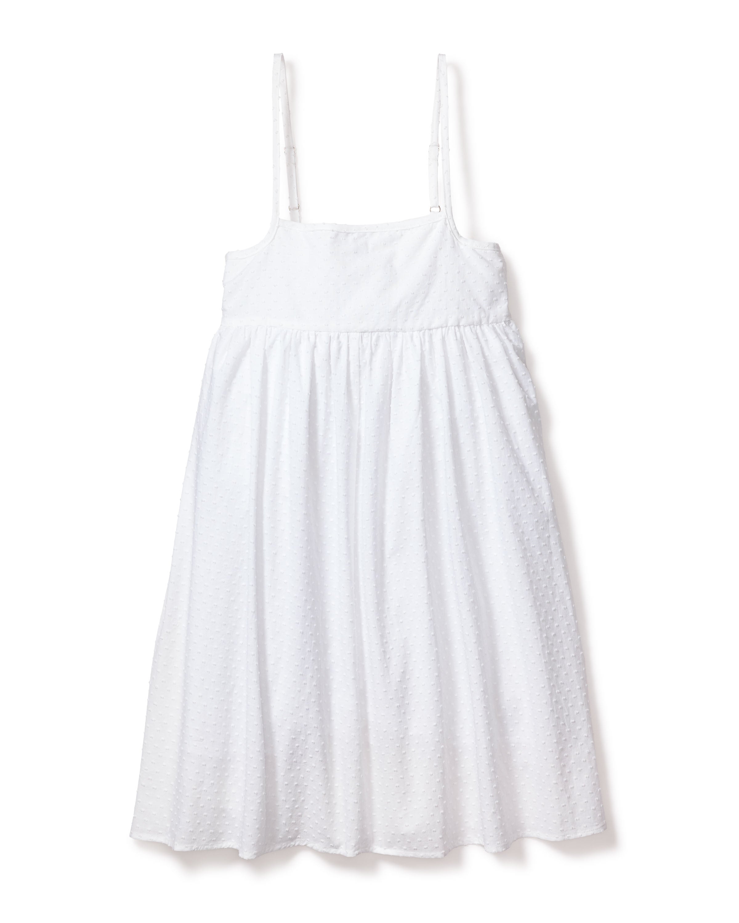 The Girls Swiss Dots Serene Day Dress by Petite Plume is a white sundress with thin shoulder straps and a textured, flowing skirt.