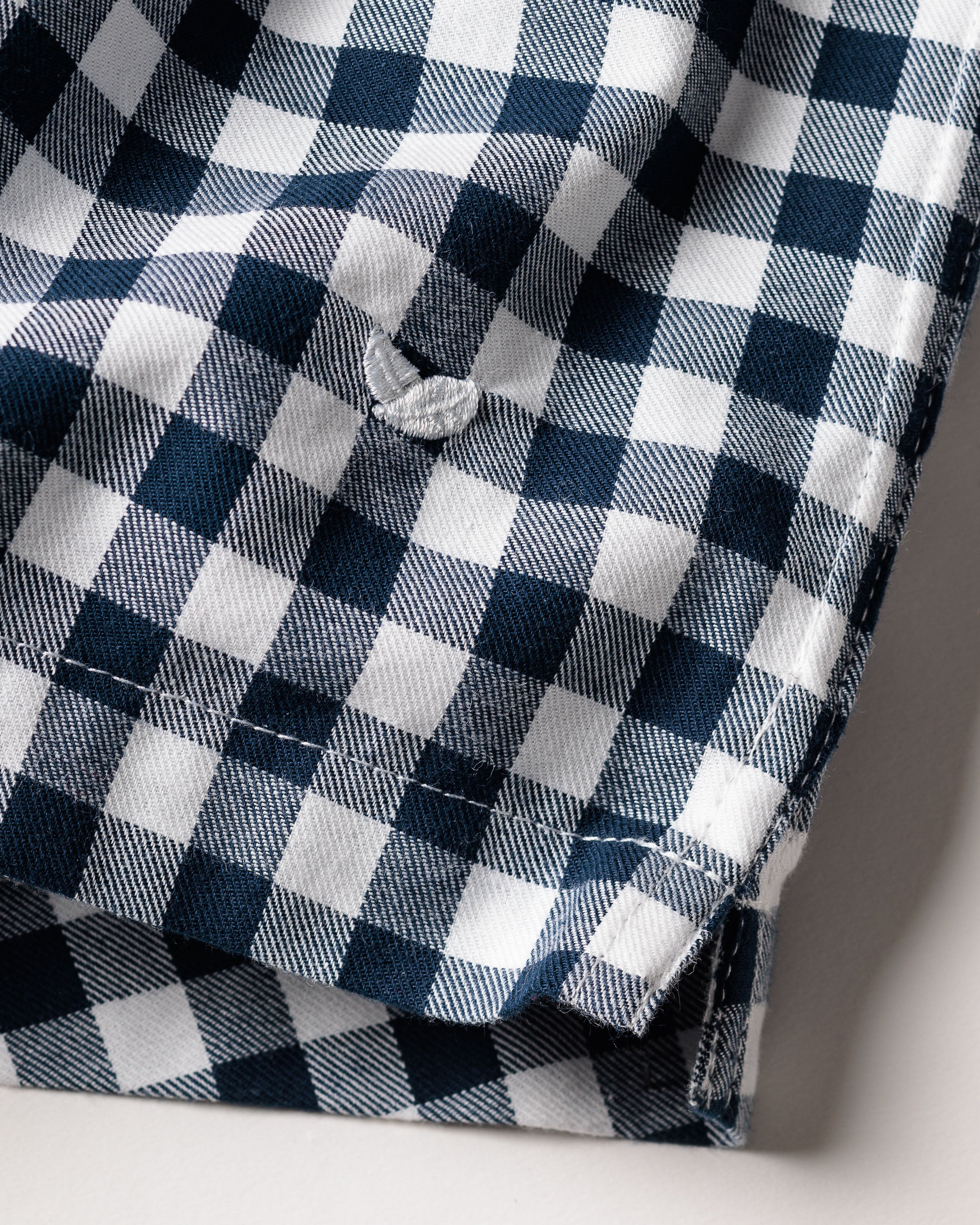 Close-up of navy checkered fabric from Petite Plumes Mens Twill 3 Pack Boxers in Navy, featuring soft cotton twill with a buttonhole, slightly wrinkled texture, and neatly hemmed bottom edge.