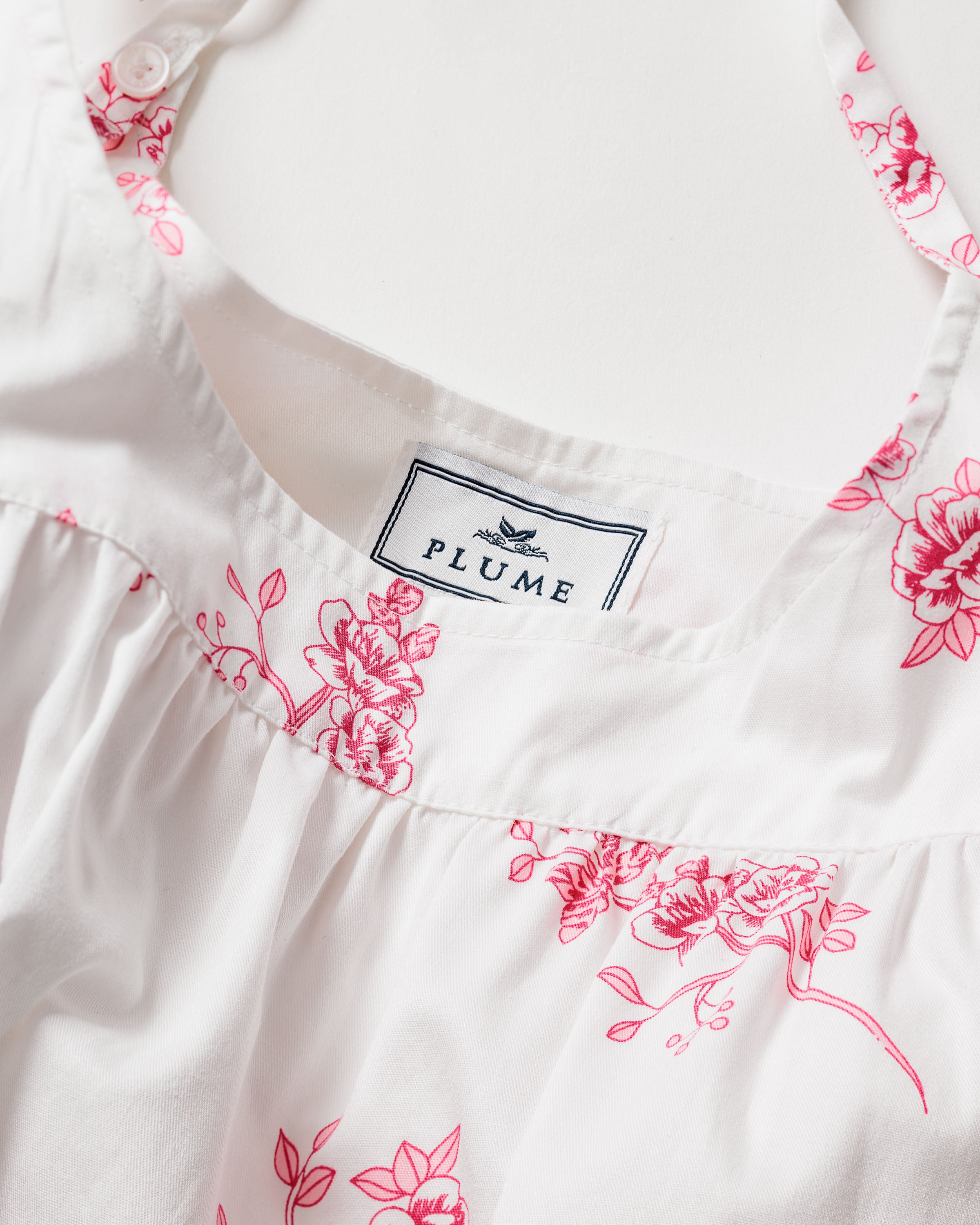 A luxurious Womens Twill Chloe Nightgown from Petite Plume is shown in close-up, featuring an English Rose Floral vintage print and a soft, delicate fabric with ruffled edges and a button on the collar.