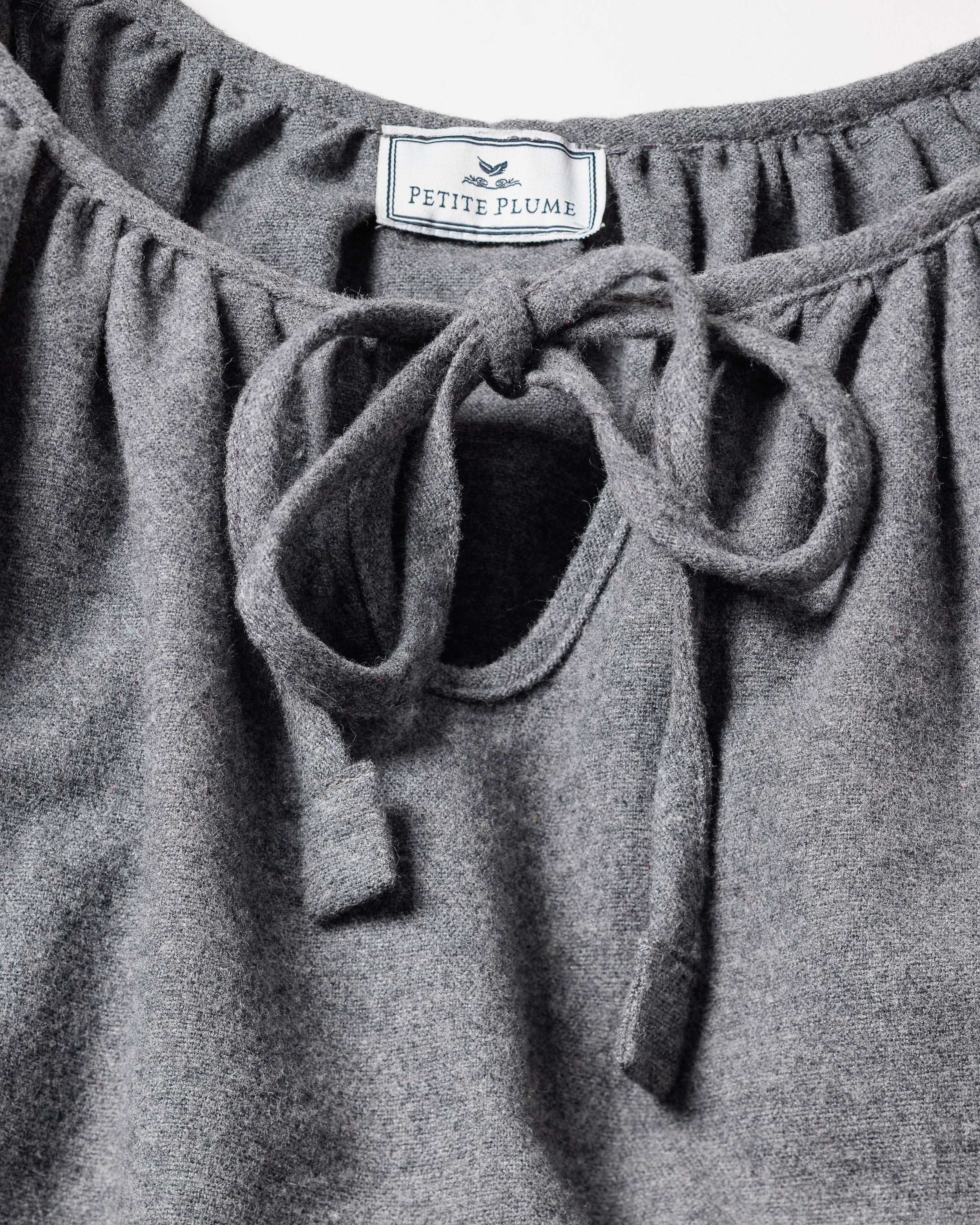 Close-up of the Petite Plume Womens Flannel Delphine Nightgown in Grey, featuring a fabric tie at the neckline and a keyhole opening. This soft flannel garment is crafted from 100% cotton for ultimate comfort.