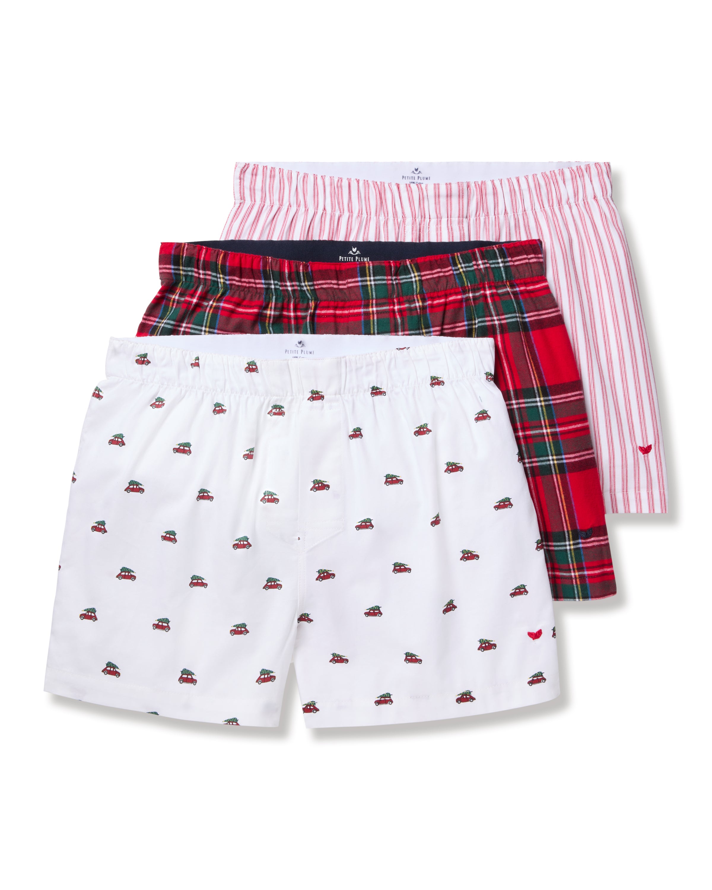 The Mens Twill 3 Pack Boxers in Holiday Red by Petite Plume include classic-fit designs: one with small car patterns on white woven cotton twill, another with a red and green plaid design, and the last featuring bold red and white vertical stripes.