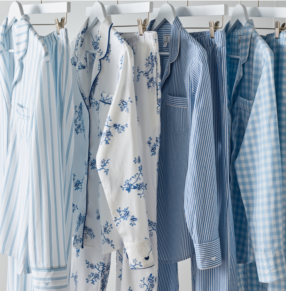 Various blue and white pajamas set hanging in a row