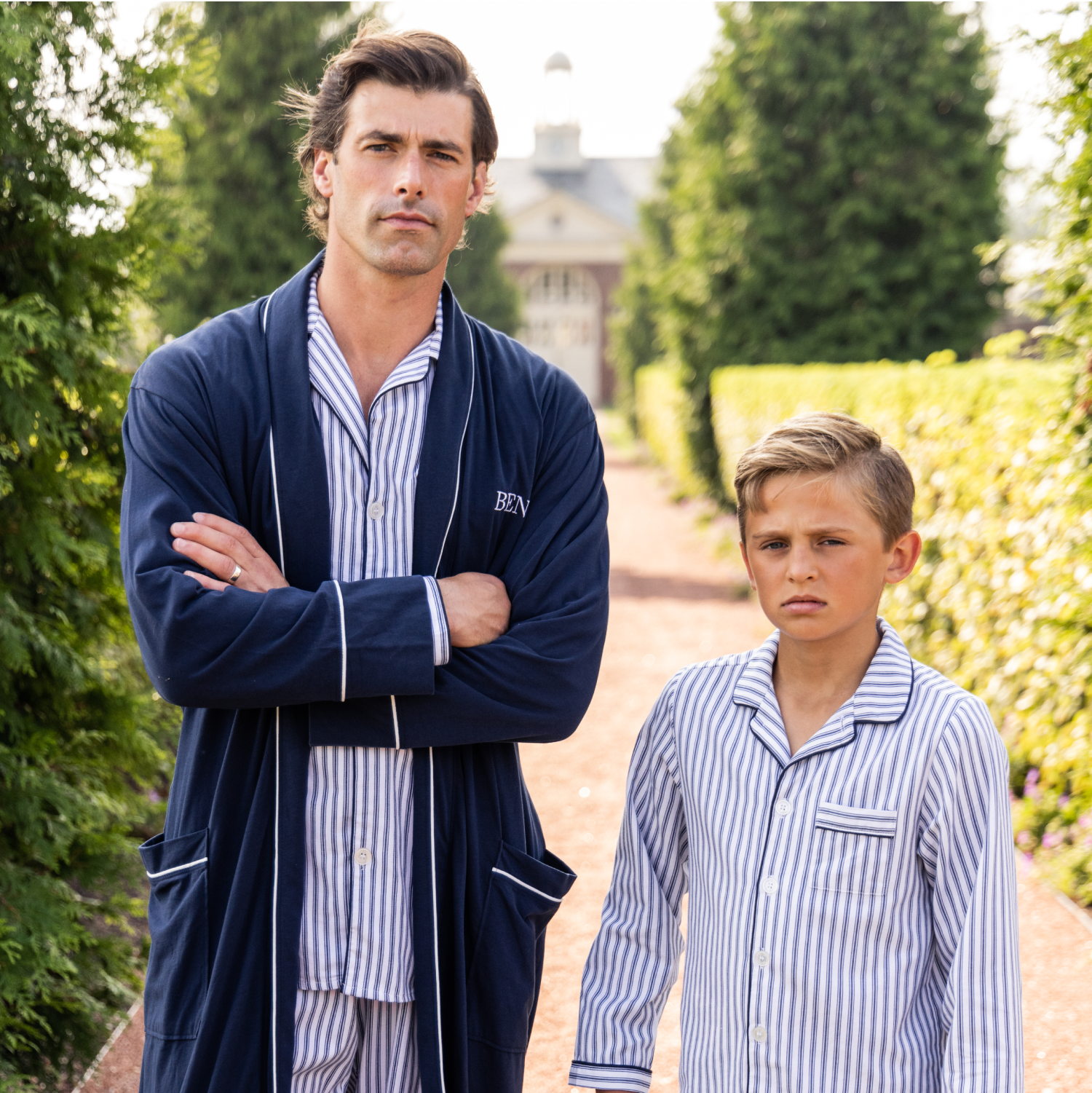 Man and young boy outside in a garden in white and navy matching pajamas