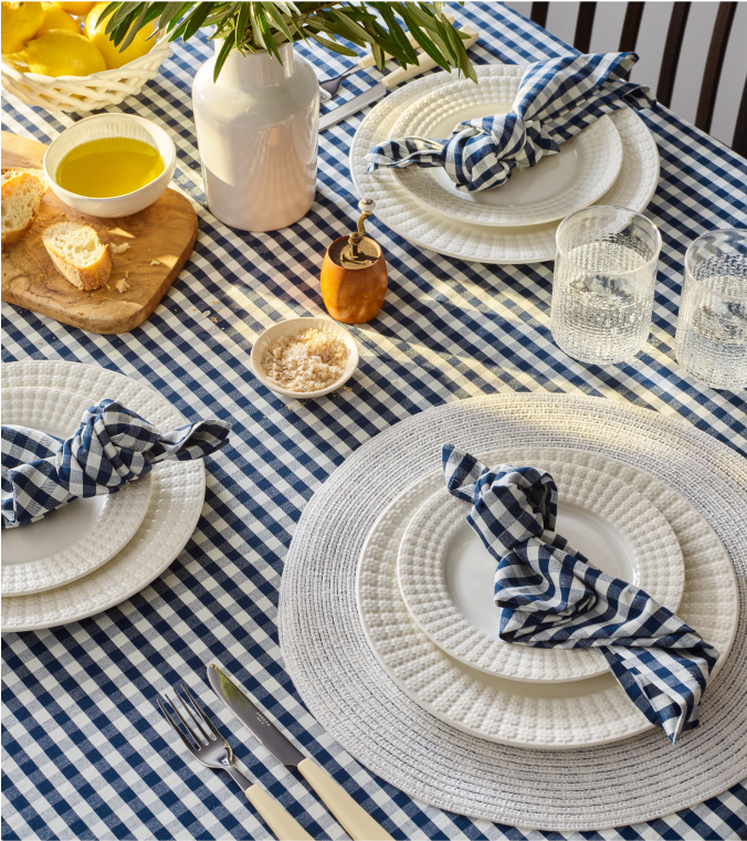 Table setting with white plates,navy and white table linens and 2 glasses of water