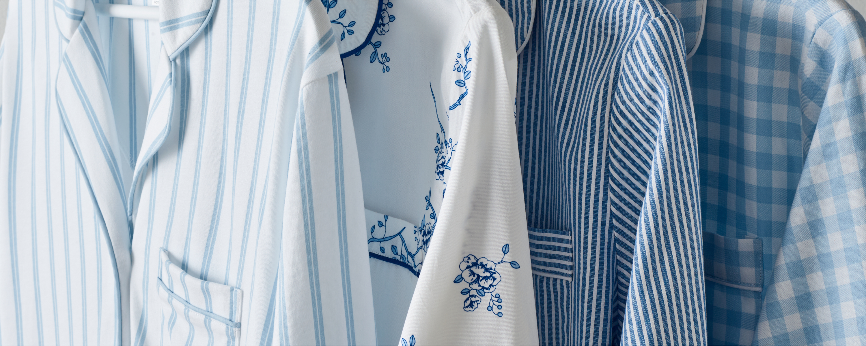Blue and white pajama tops hanging in a row