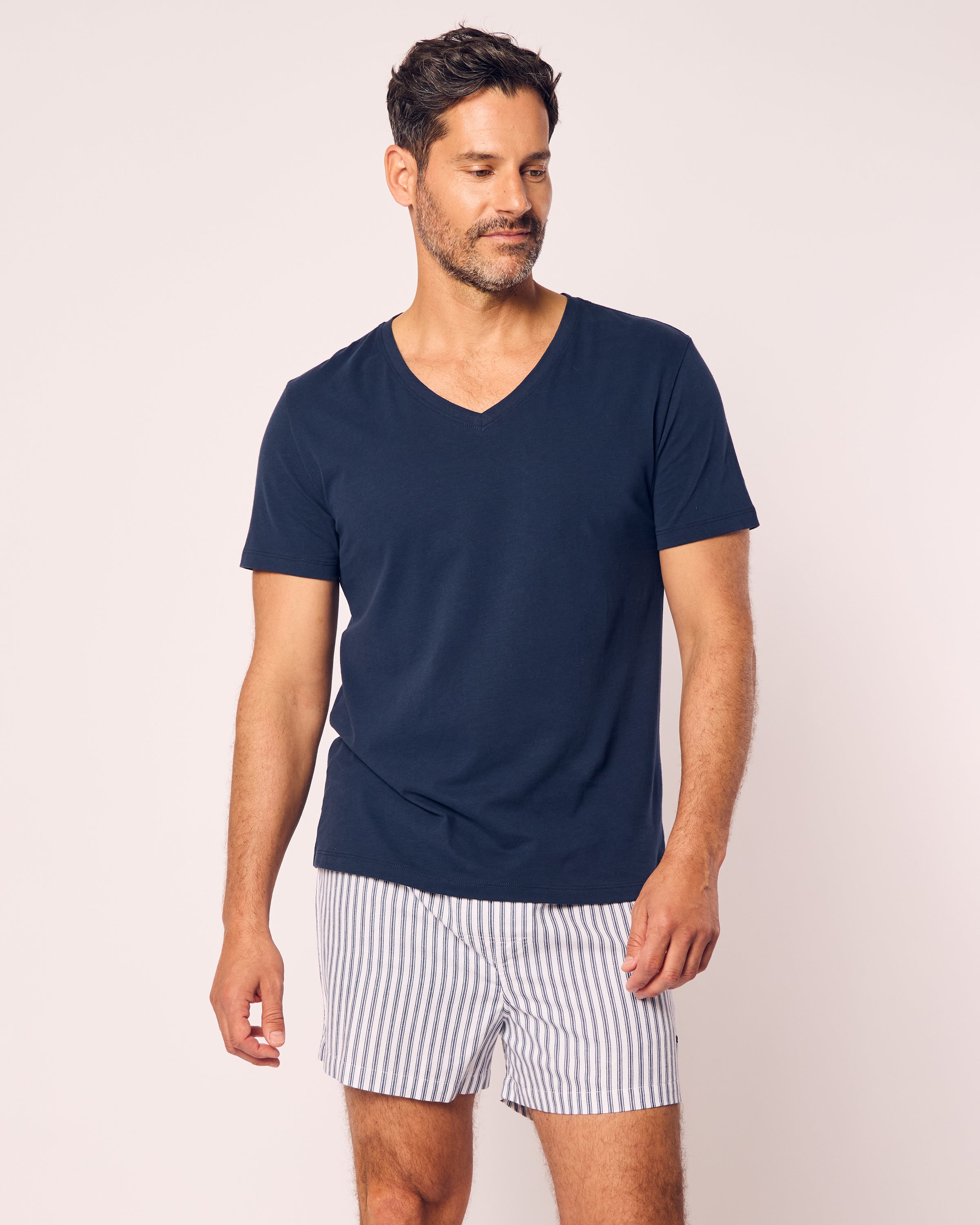 A man with short dark hair and a beard wears navy Petite Plume Mens Twill Boxers, styled against a plain light background as he looks slightly to the side.