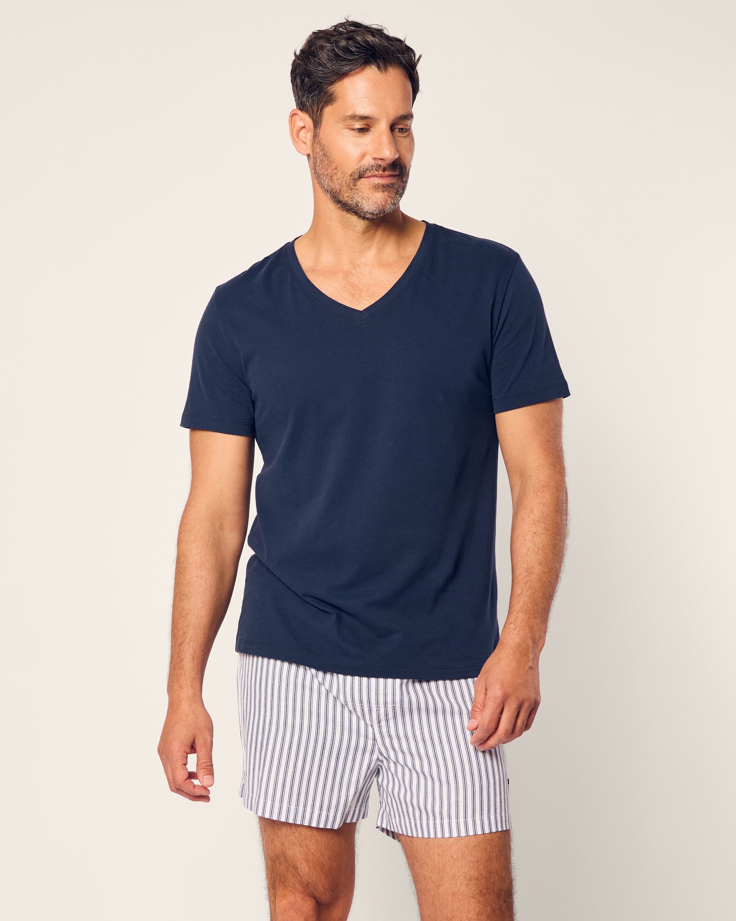 A man wearing Petite Plumes Mens Twill 3 Pack Boxers in Windsor Tartan stands against a plain light background, looking slightly to his left with a relaxed expression.