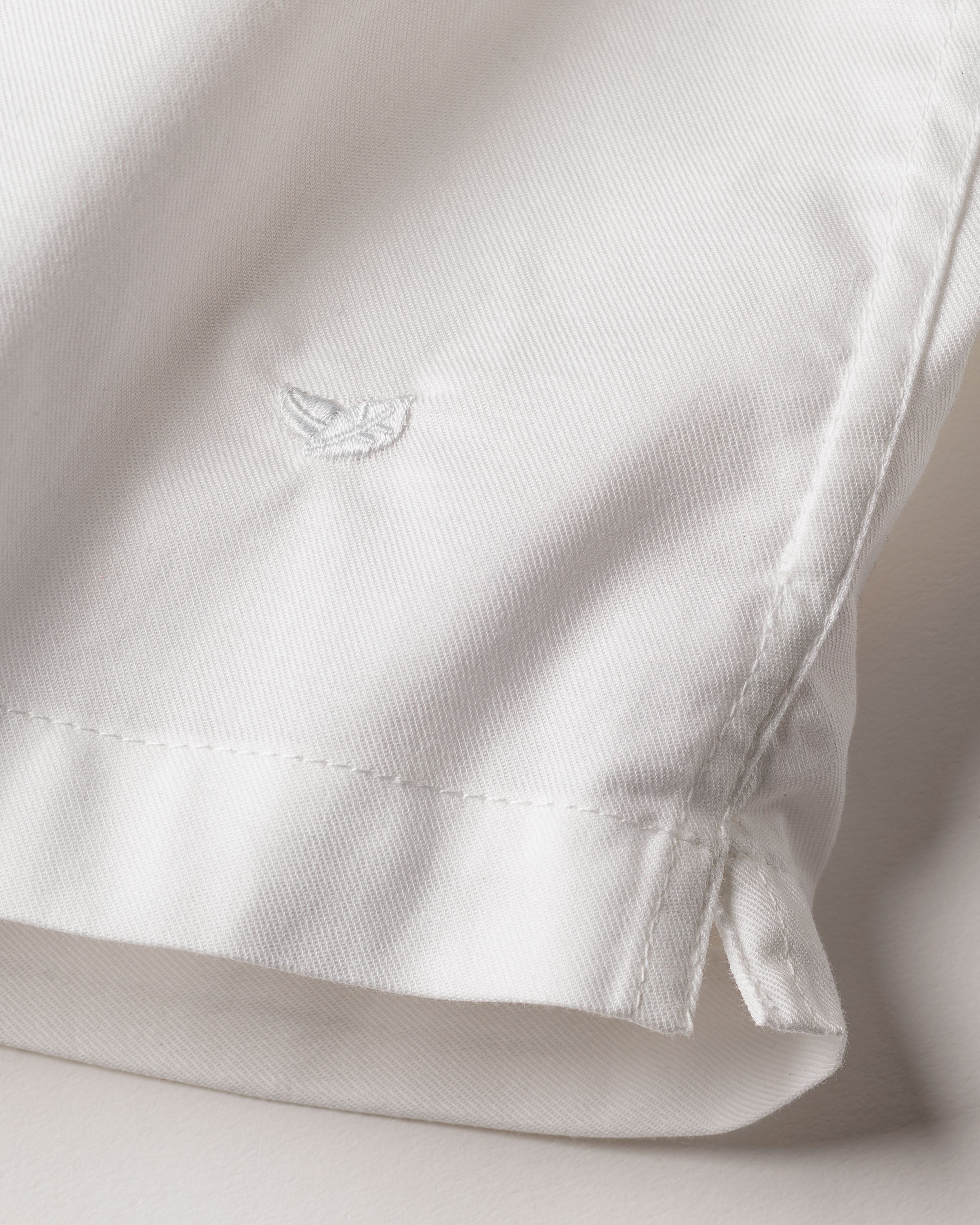 Close-up of a Royal Blue Gingham garment from Petite Plume, featuring neatly sewn seams and a small embroidered logo on woven cotton twill. The clean, minimal design of the Mens Twill 3 Pack Boxers exudes timeless elegance.