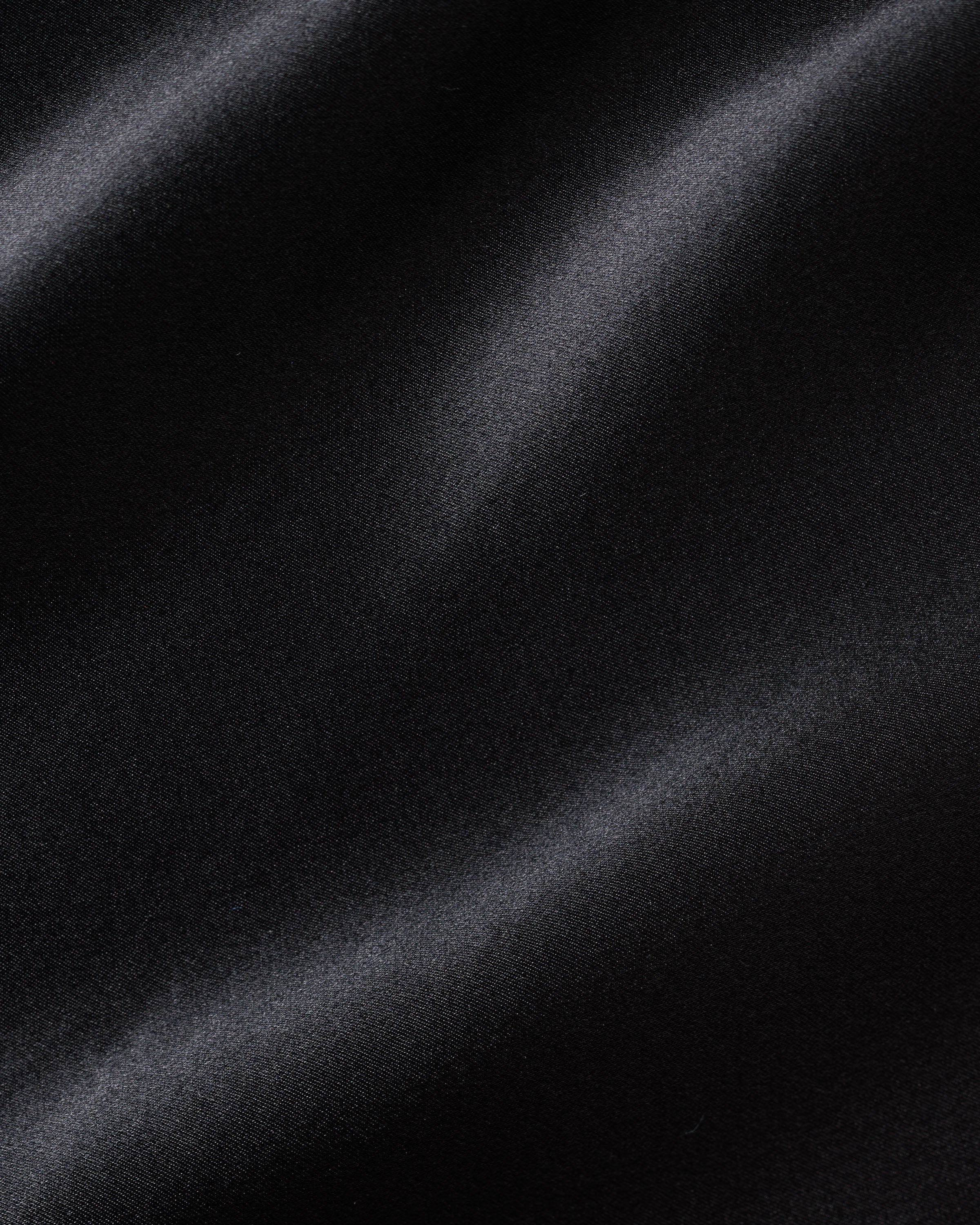 Petite Plumes Womens Silk Long Slip in Black features smooth, mulberry silk fabric with a subtle sheen and soft, flowing waves. Its gentle folds and light reflection create an elegant texture, making it perfect for exquisite sleepwear.