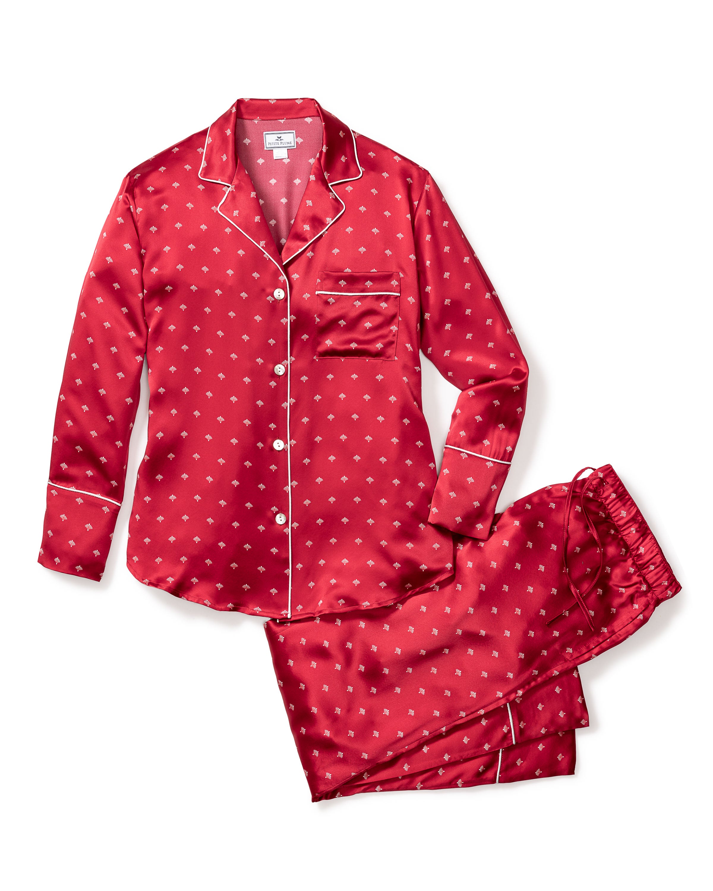 The Womens Silk Pajama Set in Crimson Art Nouveau by Petite Plume offers luxury with its red mulberry silk fabric, subtle Art Nouveau print, and elegant design. It includes a long-sleeve button-up top with chest pocket and white piping, paired with matching drawstring pants for those who cherish luxurious sleepwear.
