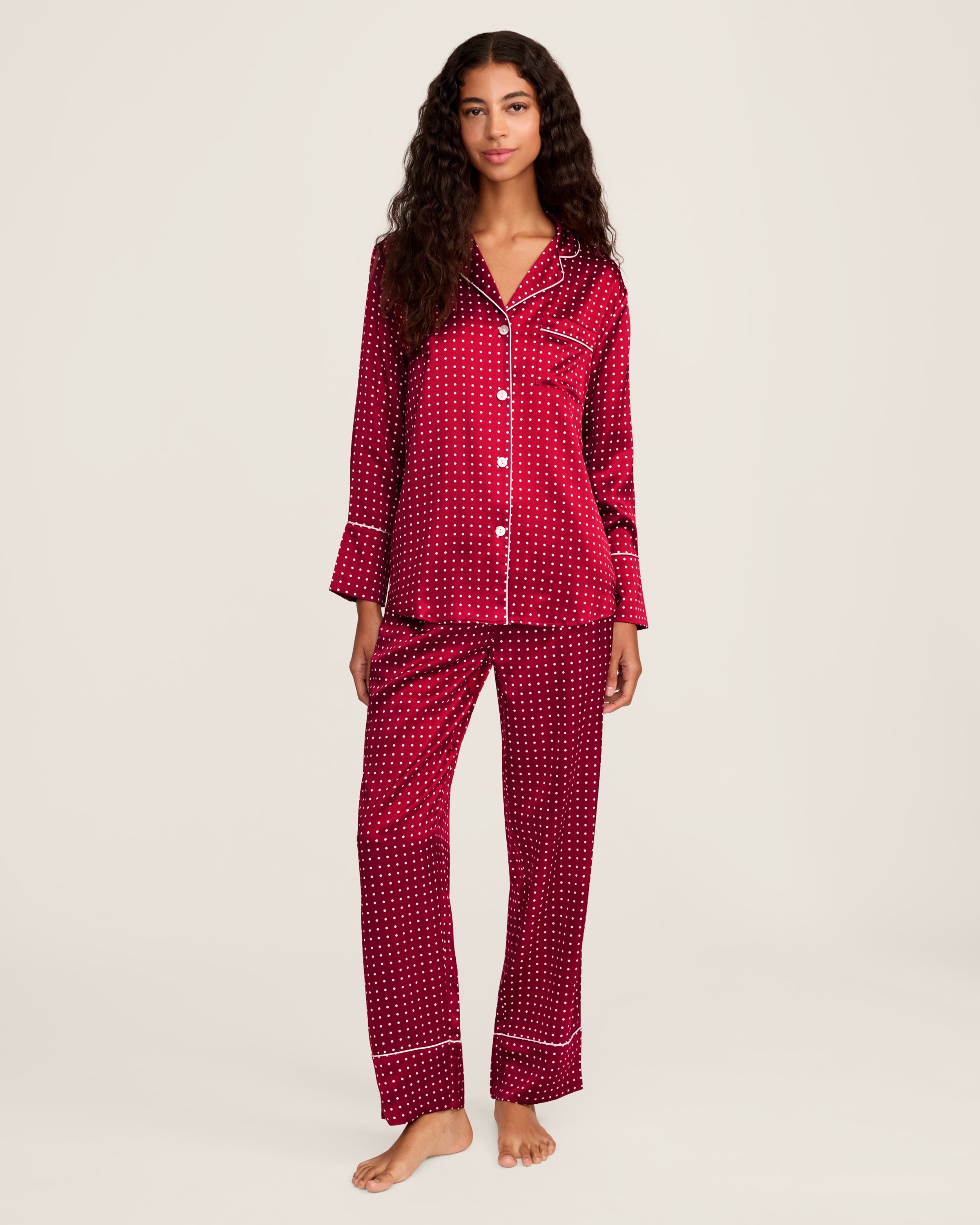 Experience luxury sleepwear with Petite Plumes Womens Silk Pajama Set in Bordeaux Polka Dot, featuring a bright red button-up long-sleeve top with white dots and piping, crafted from breathable mulberry silk, paired with matching pants.