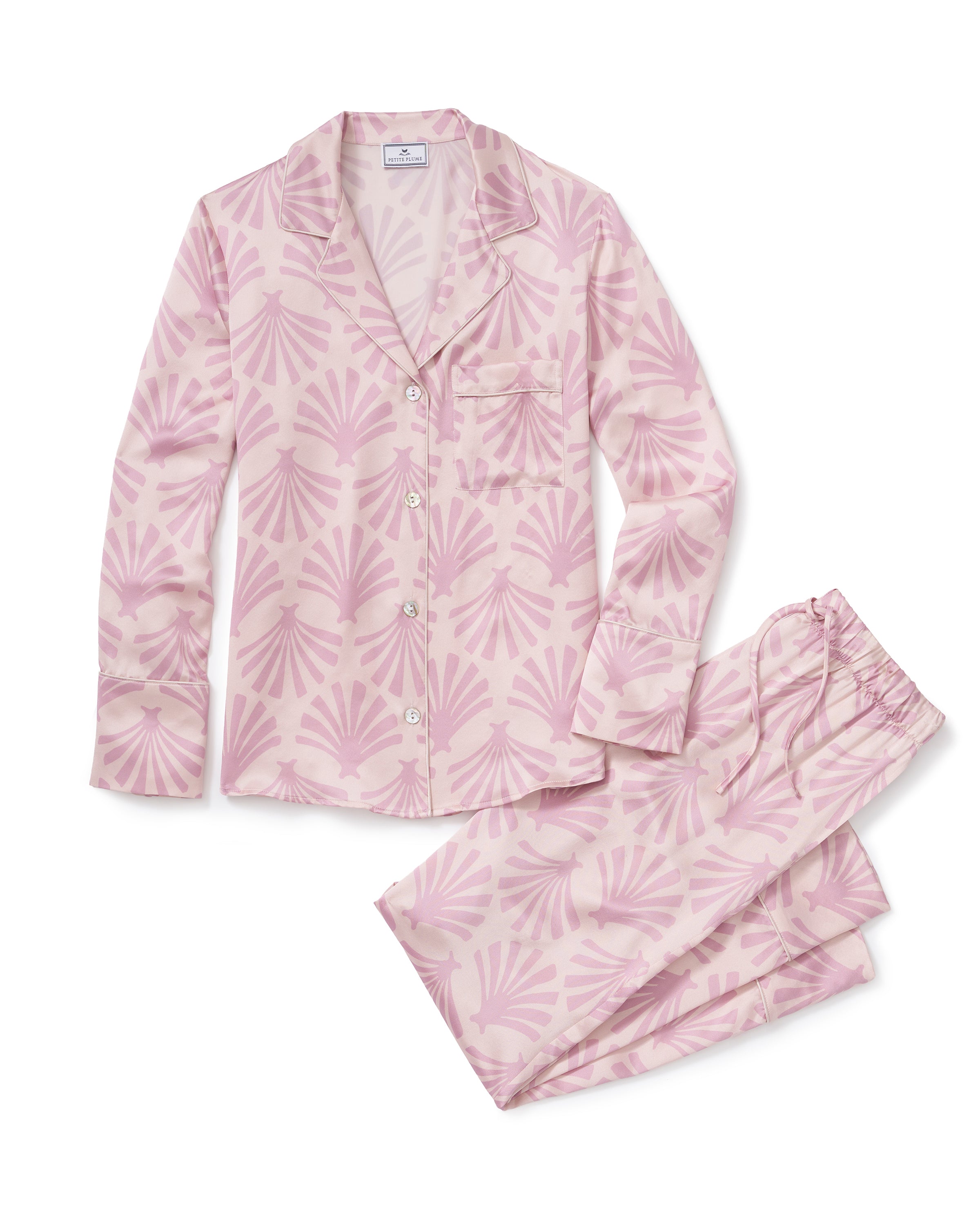 The Women's Silk Pajama Set in Blush Tide features pink long-sleeved, button-up top with collar and pocket, adorned with a blush and mauve geometric fan pattern, shown flat with matching pants beside the top.