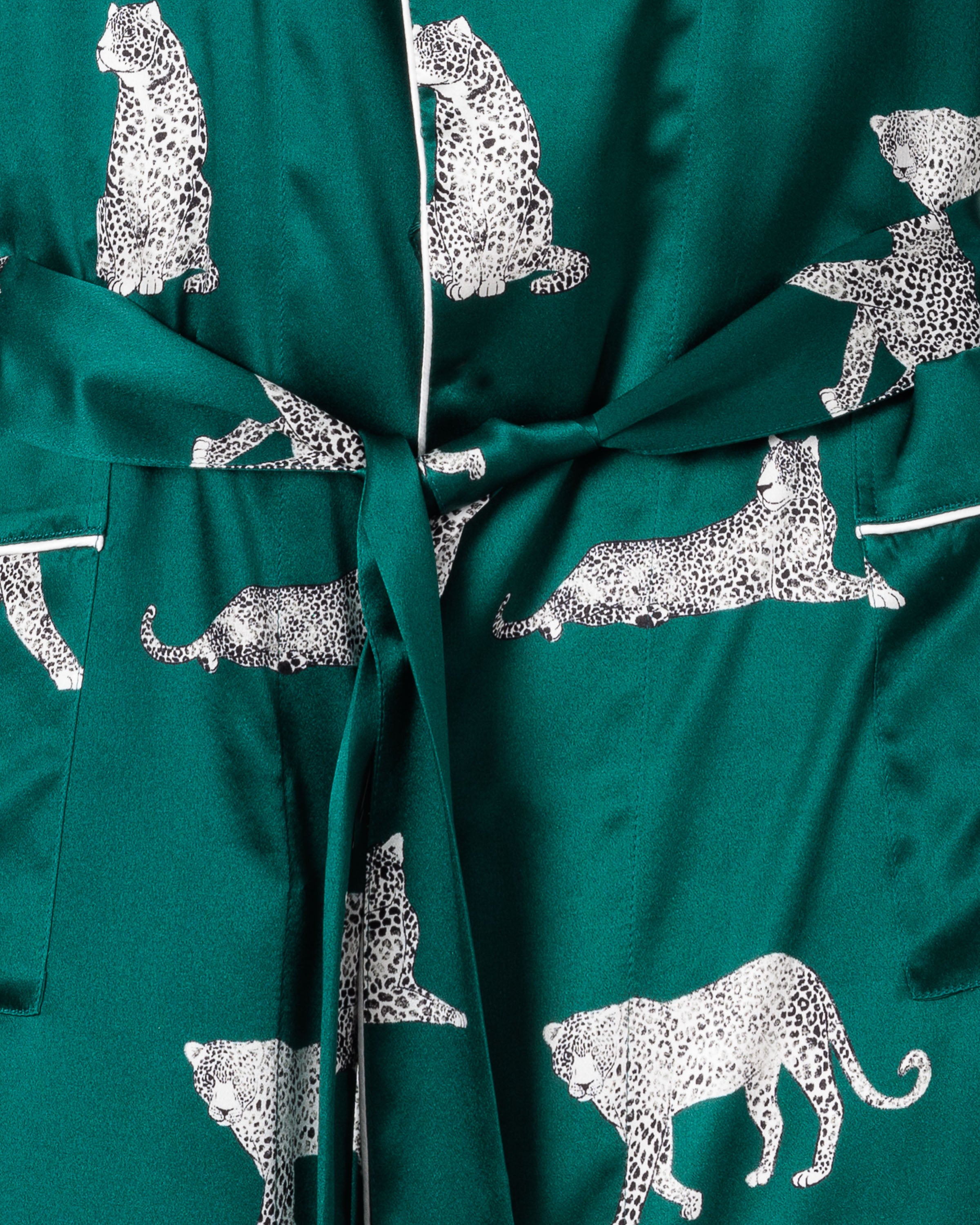 Close-up of the Womens Silk Long Robe in Panthère de Luxe by Petite Plume, showcasing a luxurious mulberry silk fabric with intricate white leopard designs—ideal for elegant sleepwear. The robe is tied at the waist, highlighting leopards on a vibrant background.