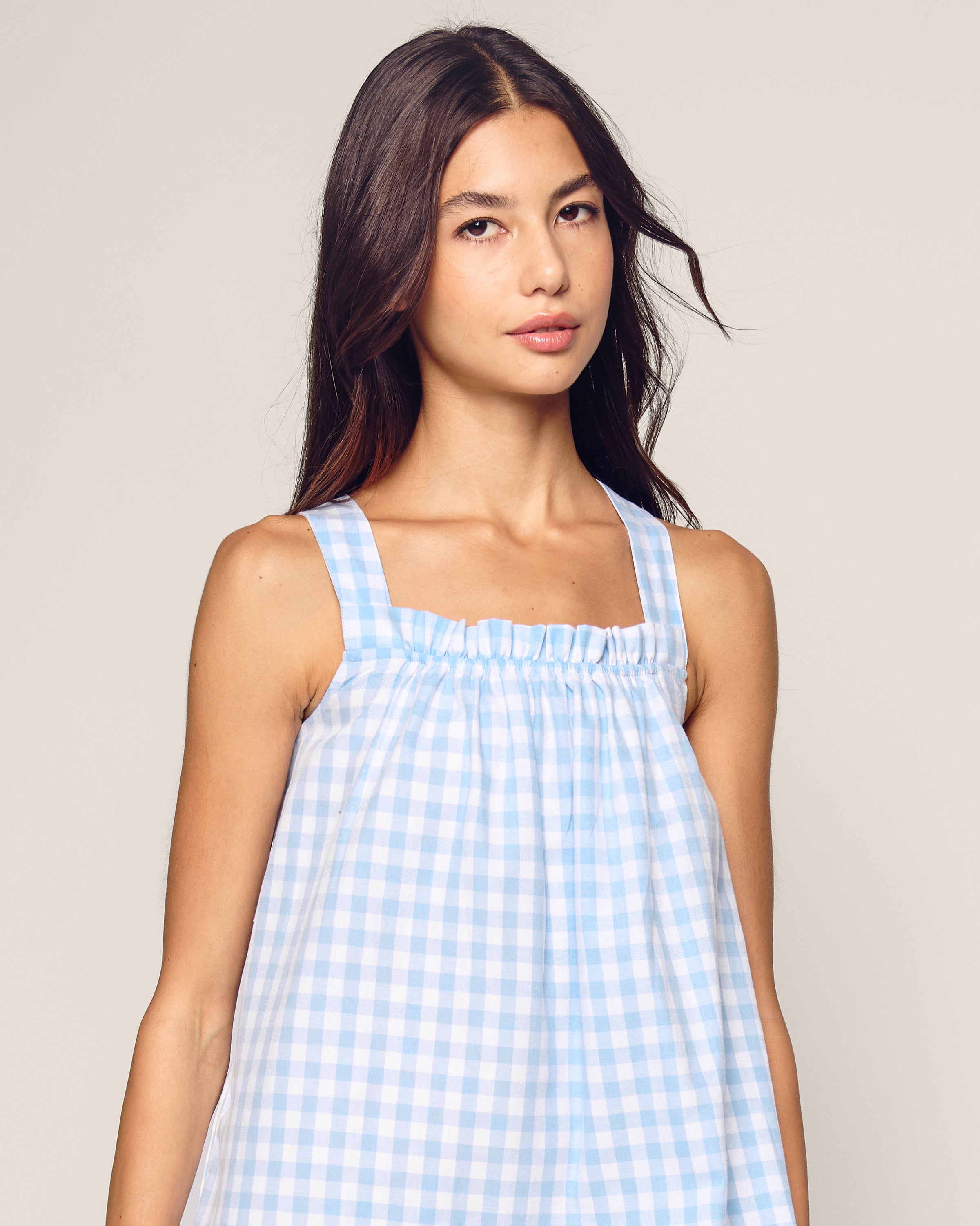 The Women's Twill Annabelle Nightgown in Light Blue Gingham features wide shoulder straps, a light blue and white gingham pattern, a gathered elastic neckline, relaxed fit, and above-knee length.