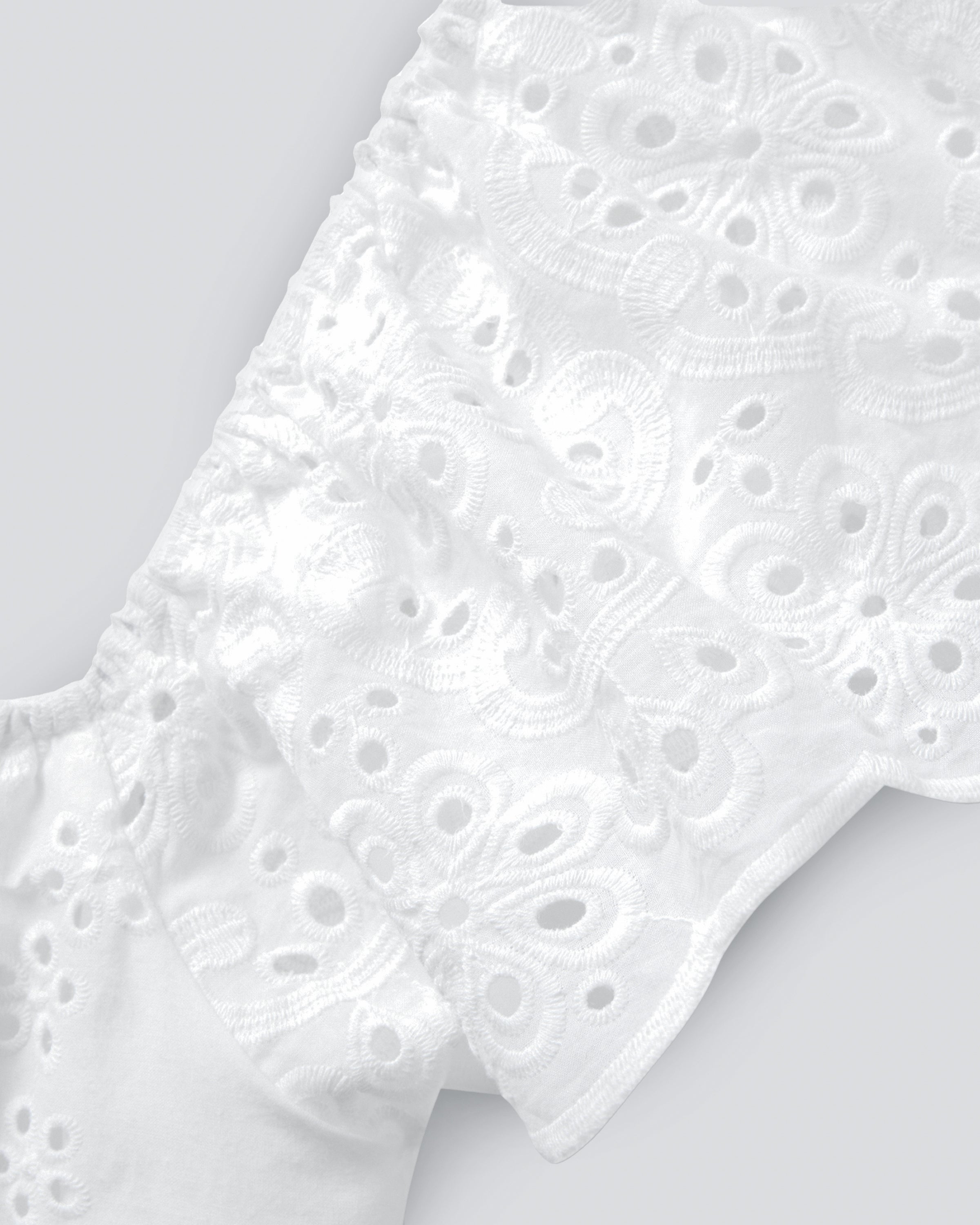 The Womens Twill Ava Nightgown in White by Petite Plume features intricate eyelet embroidery and swirling designs on textured fabric, creating a delicate, airy look ideal for crafting elegant luxury sleepwear.