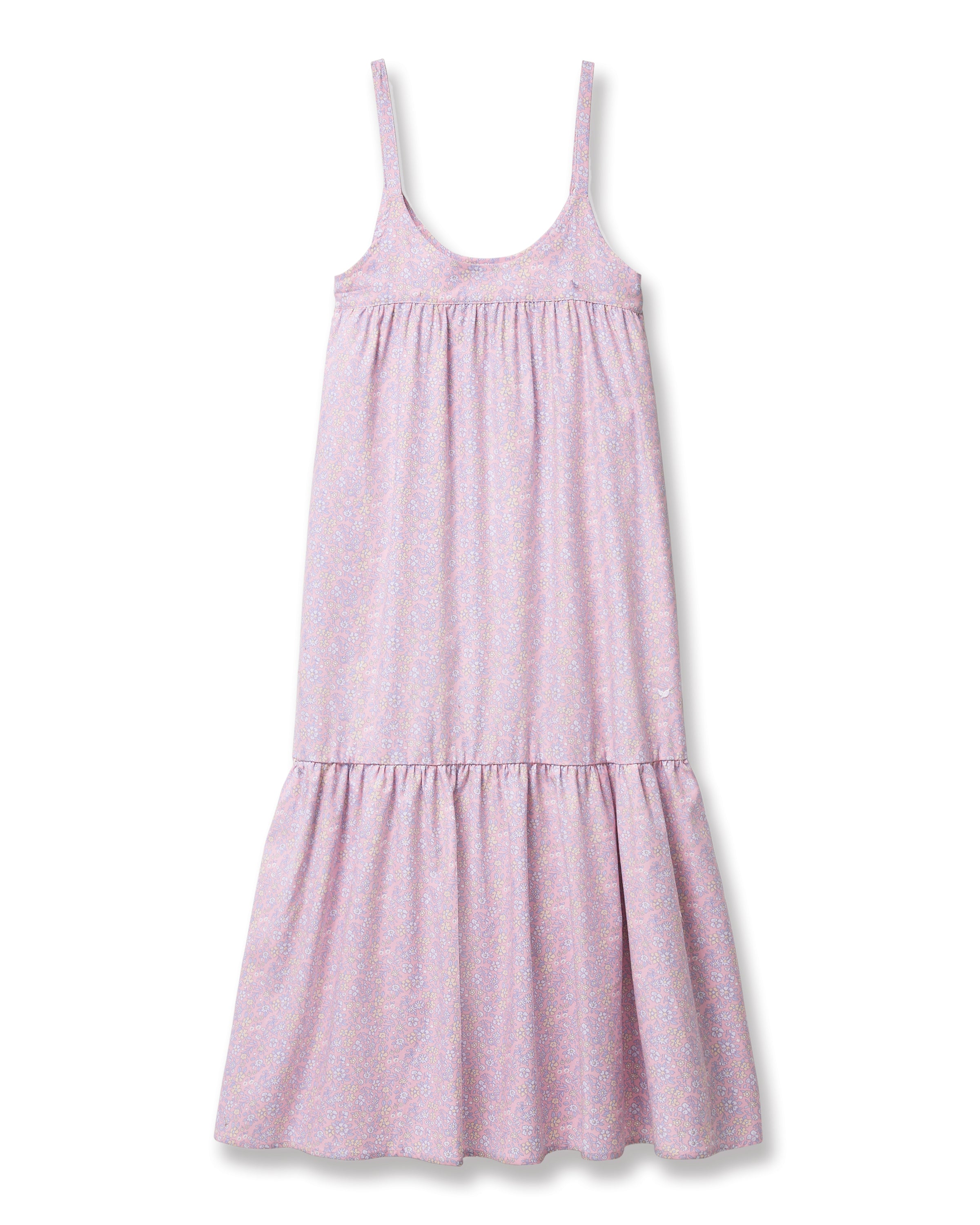 A woman with long curly hair models the Women's Twill Chloé Nightgown in Fleur Blush, a sleeveless, loose-fitting light purple floral dress. She is barefoot and stands relaxed against a plain, light background.