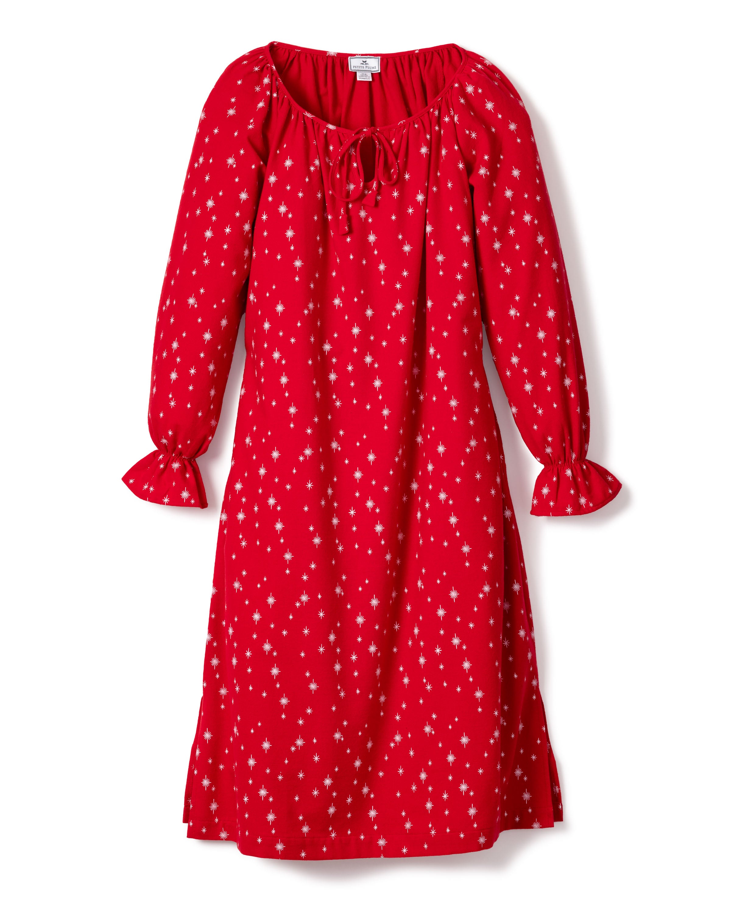 The Womens Flannel Delphine Nightgown in Starry Night by Petite Plume offers a red, long-sleeved midi design with small white stars, reminiscent of a dress. It features gathered cuffs, a tie neckline, and is crafted from lightweight flannel for comfort and style.