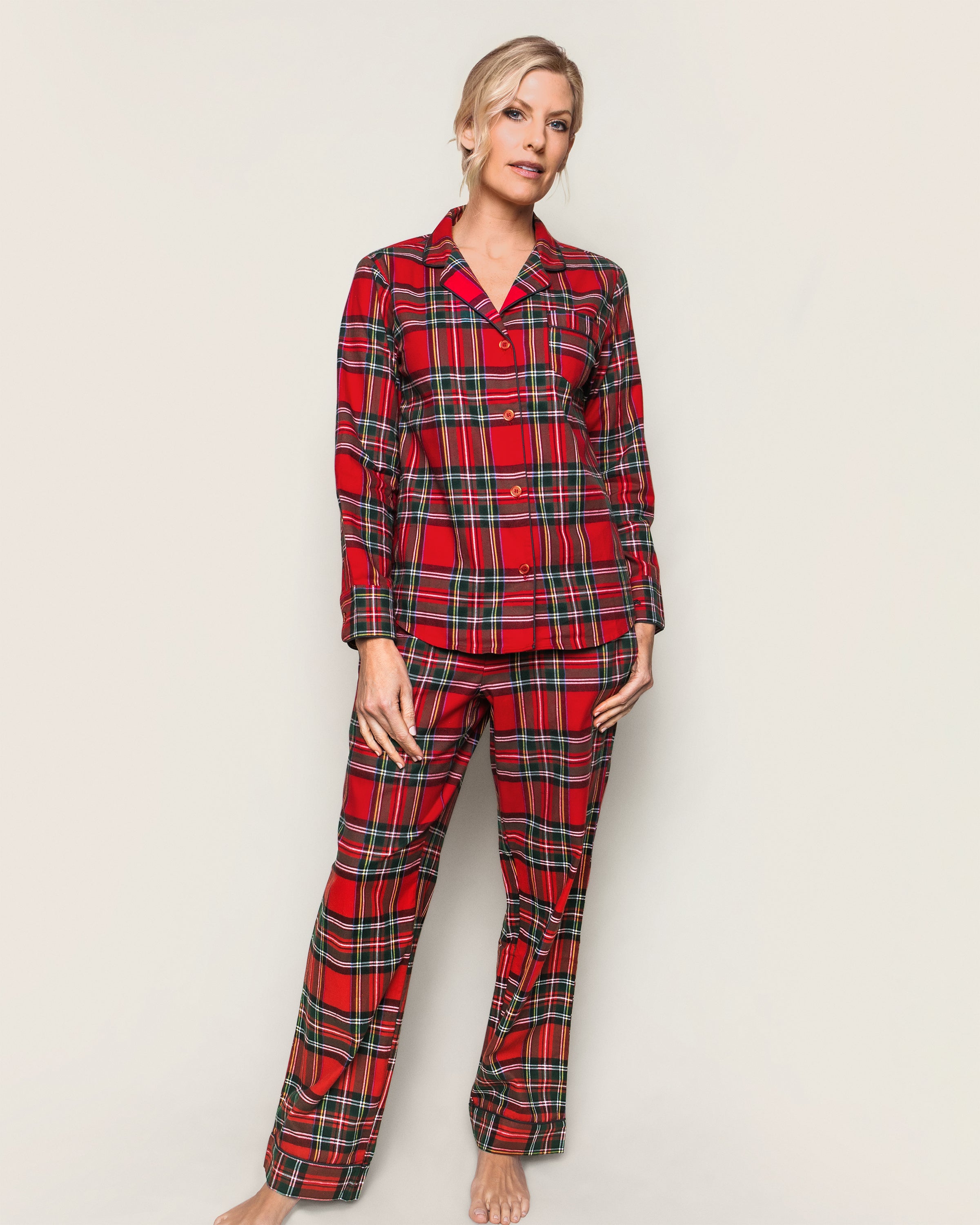 A person in a Petite Plume Womens Brushed Cotton Pajama Set in Imperial Tartan stands barefoot against a light background. They have short, blonde hair and are posing with their hands relaxed by their sides.