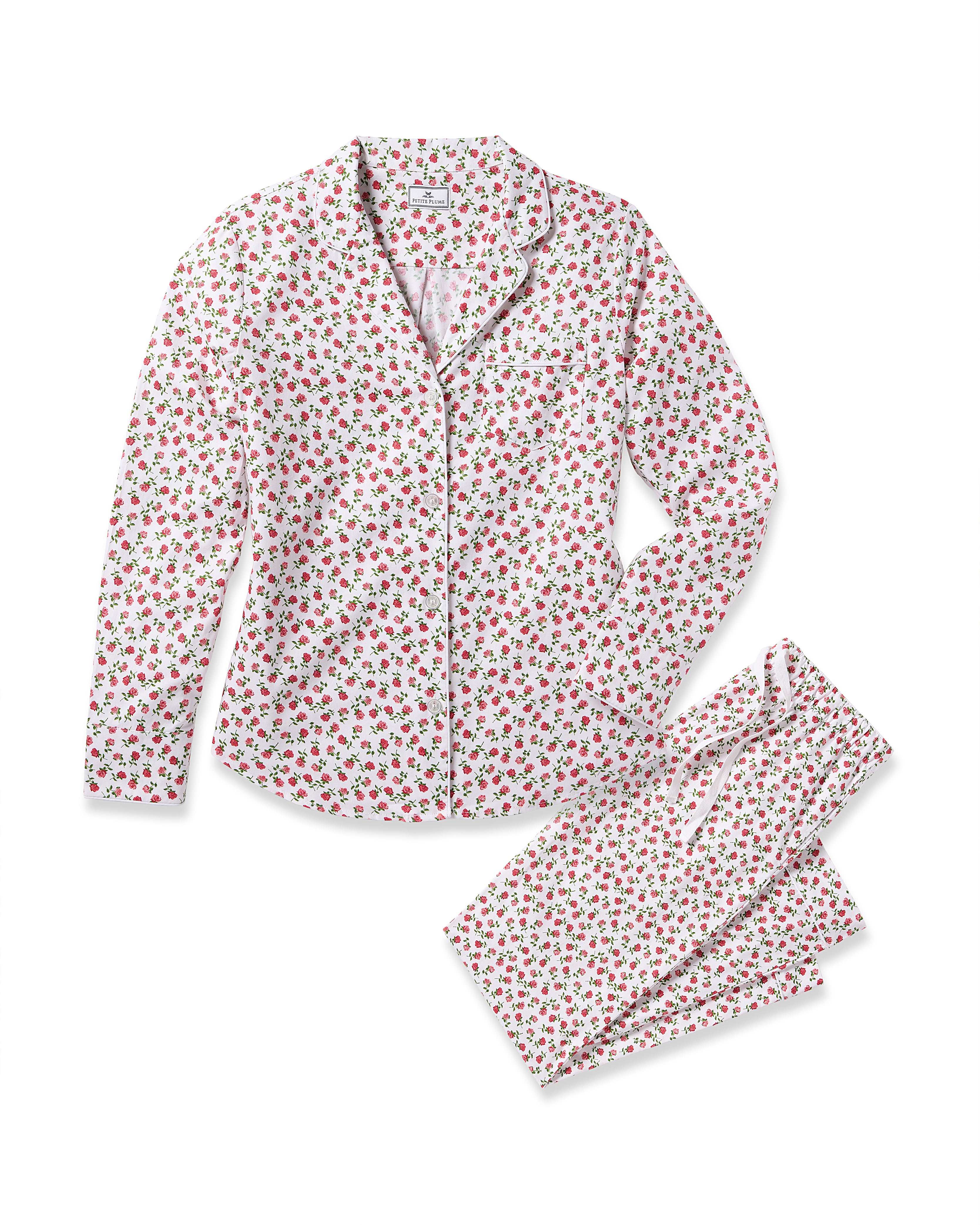 Indulge in luxury sleepwear with Petite Plumes Womens Twill Pajama Set in Petite Petals, featuring a white background adorned with small red flowers. The set includes a long-sleeve, button-up top with a collar and matching pants with a comfy drawstring waist.