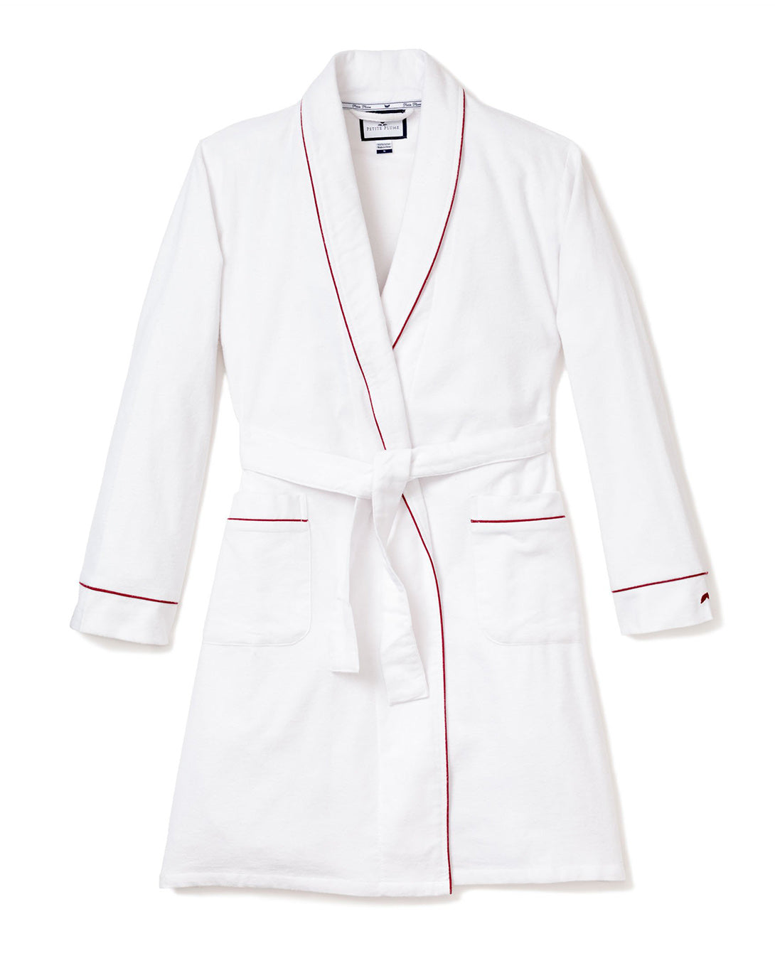 The Womens Flannel Robe in White with Red Piping by Petite Plume offers year-round comfort with its shawl collar, long sleeves, front pockets, and matching belt. Displayed flat against a white background.