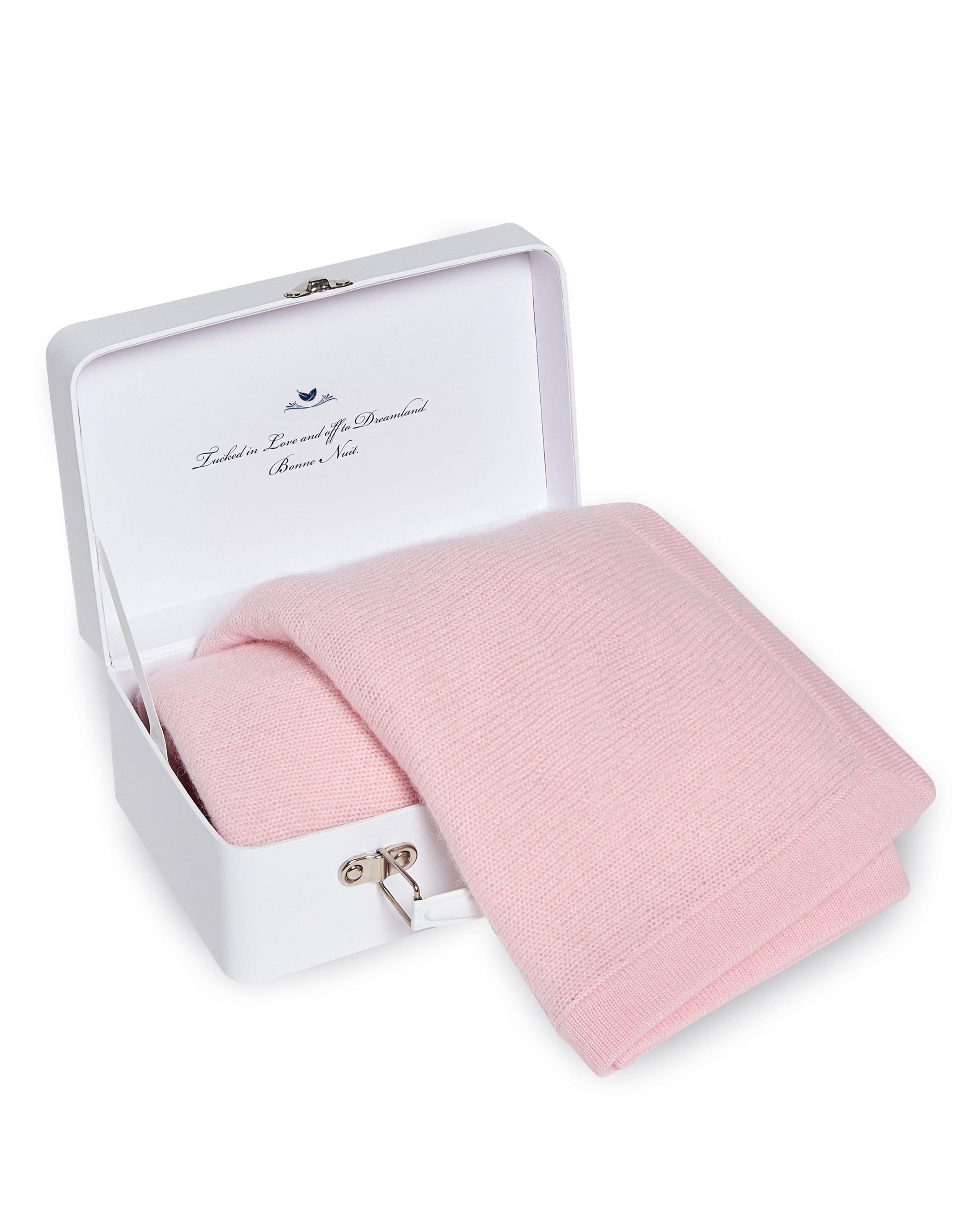 The Cashmere Baby Blanket in Rose by Petite Plume is handmade in Nepal, folded inside a white box with a silver latch. The luxury baby gifts interior lid showcases a printed message and an illustration of a small blue bird.